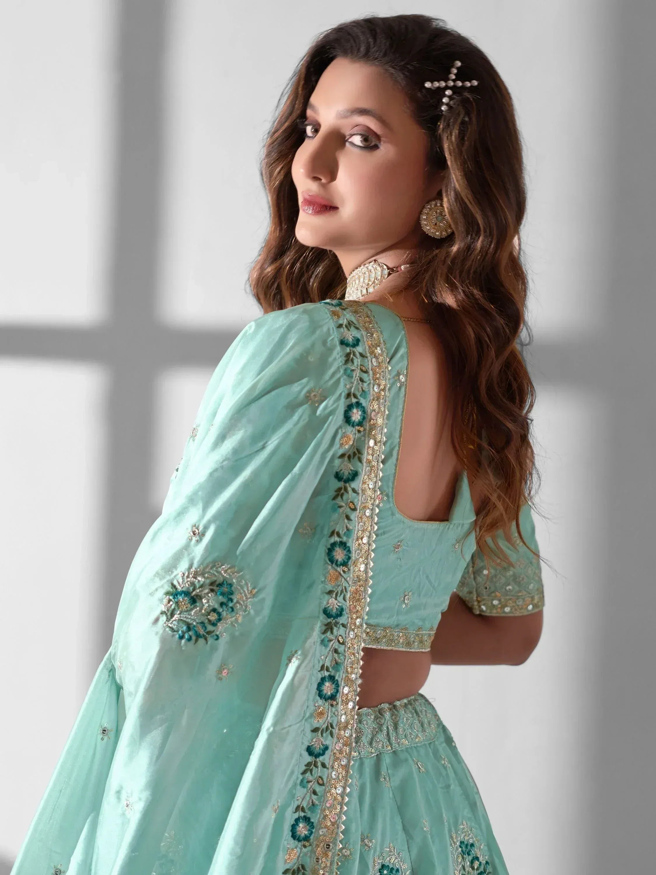 Mint green embroidered lehenga choli with floral detailing and open back design, perfect for Indian ethnic wear.