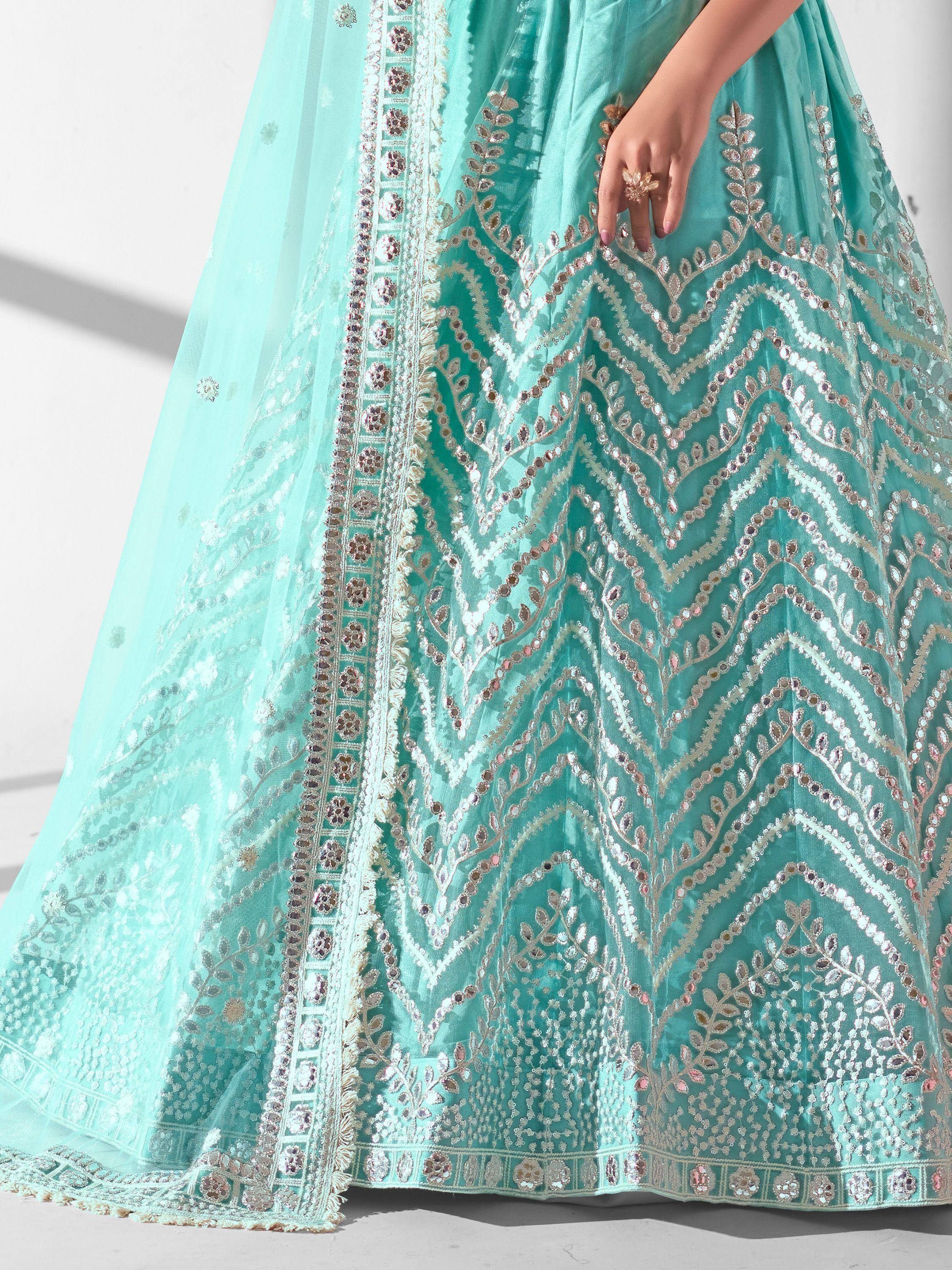 Mint green designer lehenga with intricate silver embroidery and mirror work, perfect for Indian ethnic wear.