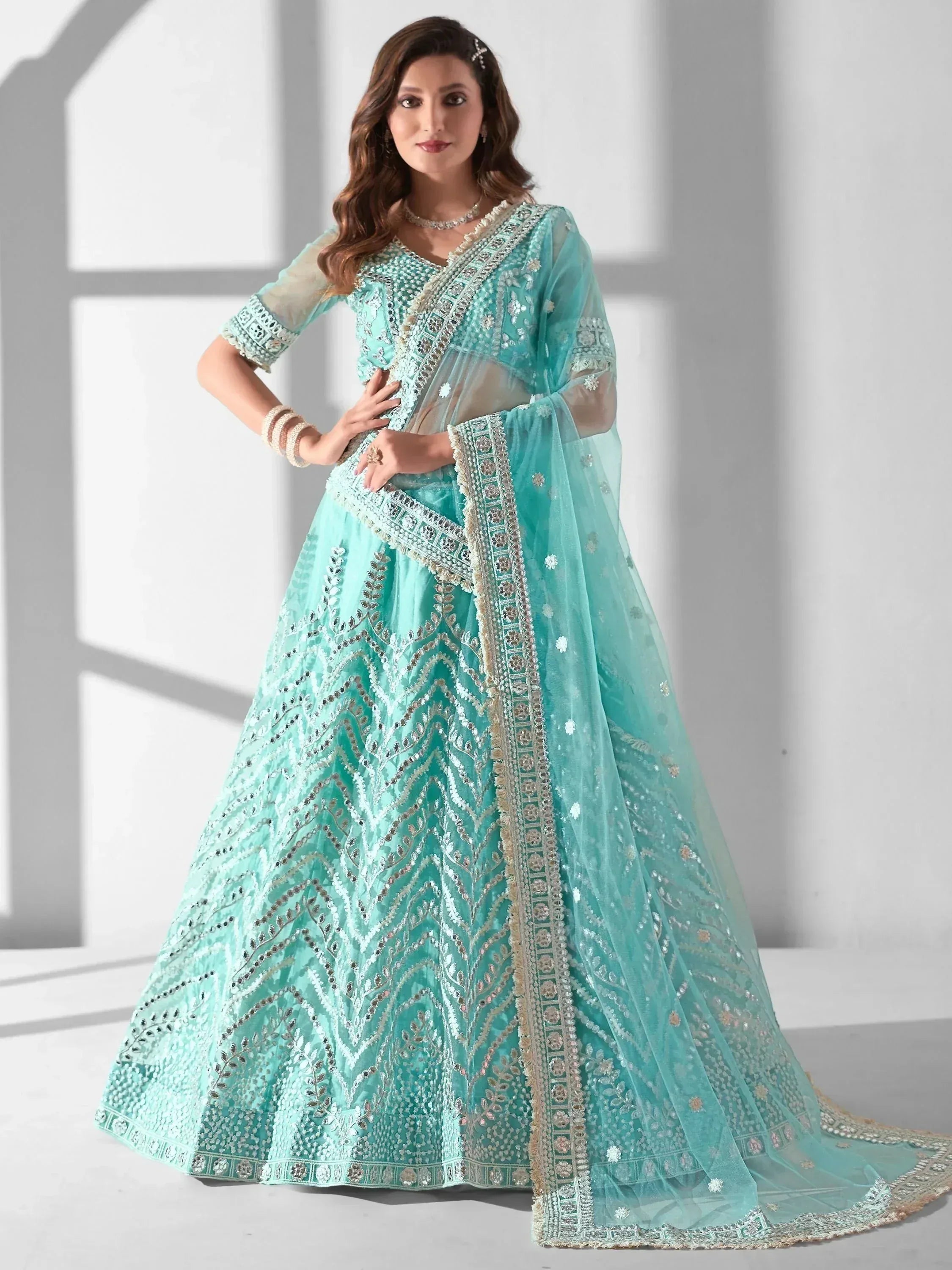 Mint green designer lehenga choli with heavy embroidery and sheer dupatta for Indian ethnic wear