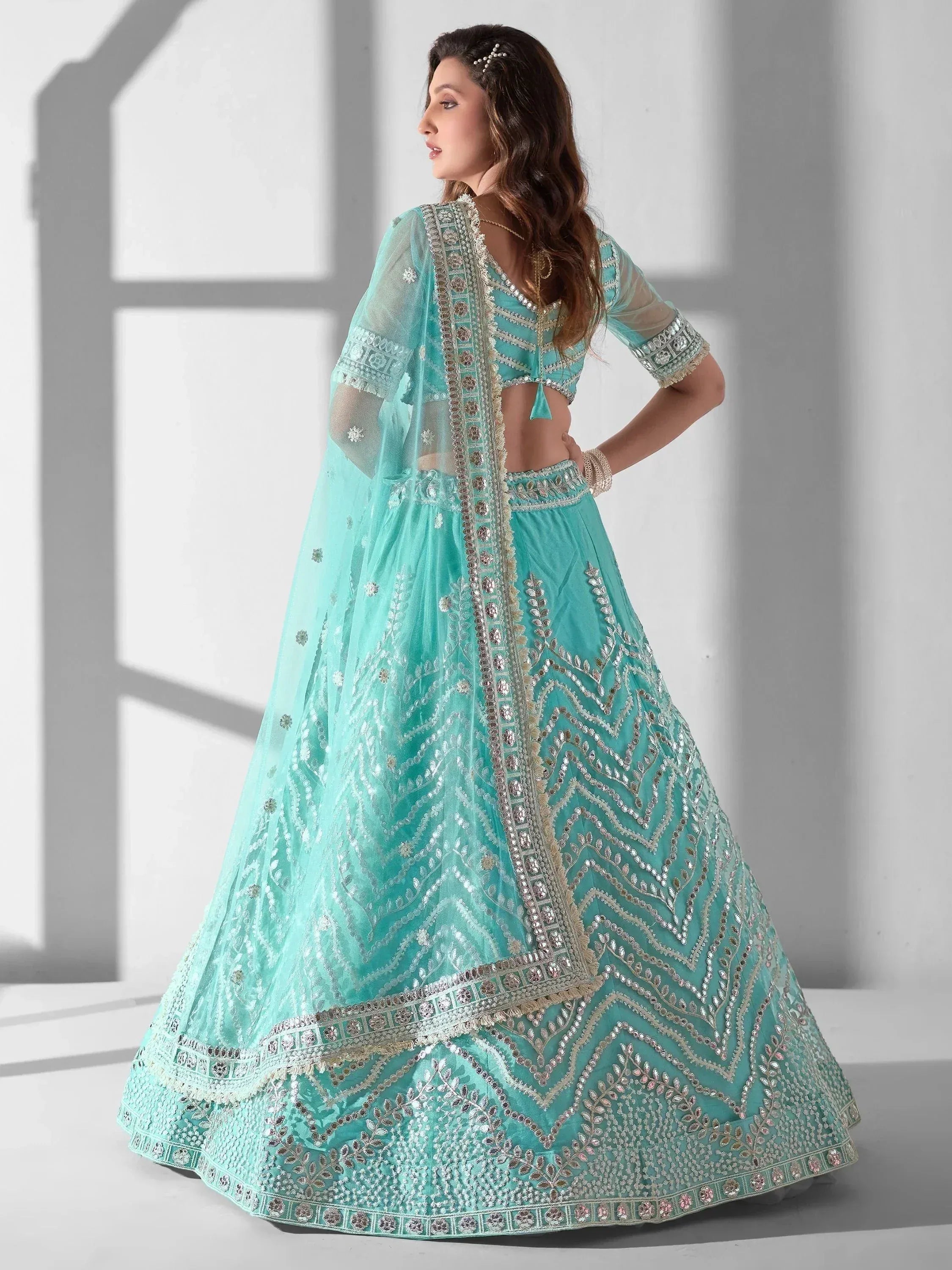 Mint green designer lehenga choli with heavy embroidery and sheer dupatta, perfect for weddings and festive occasions
