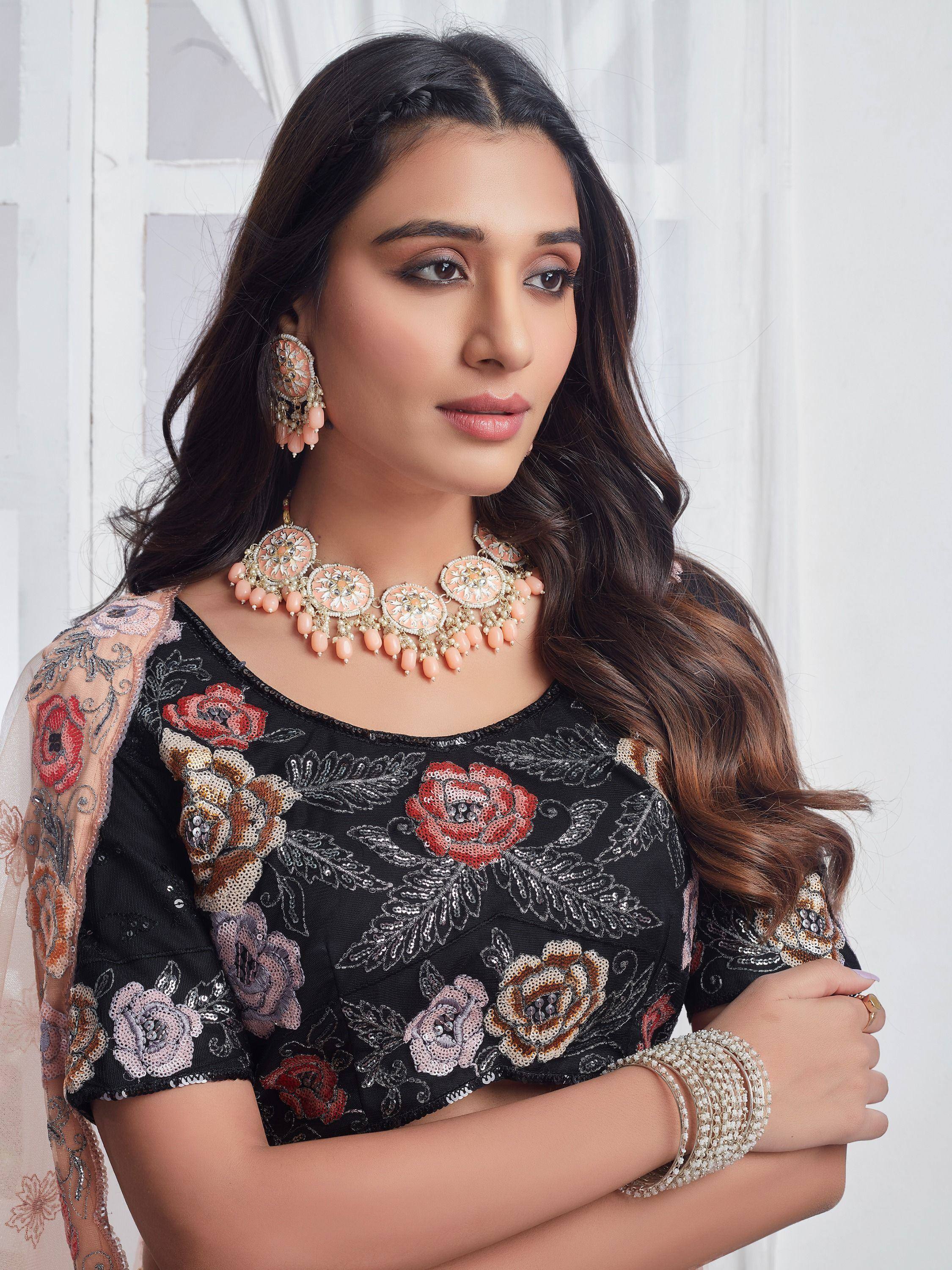 Black floral sequin top with peach jewelry, perfect for Indian ethnic wear and festive occasions.