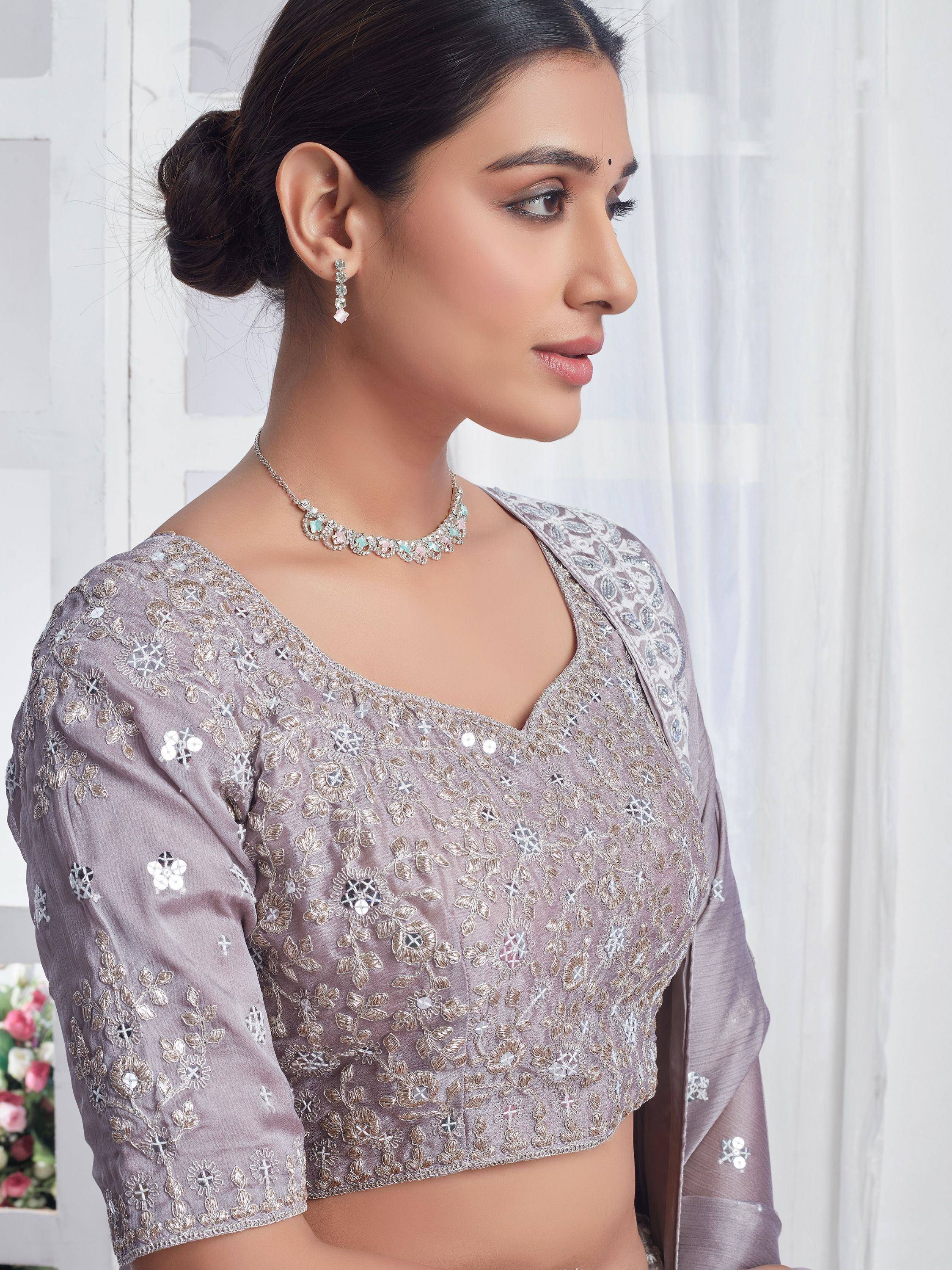 Elegant lavender embroidered blouse with mirror work, paired with delicate jewelry for Indian ethnic wear.