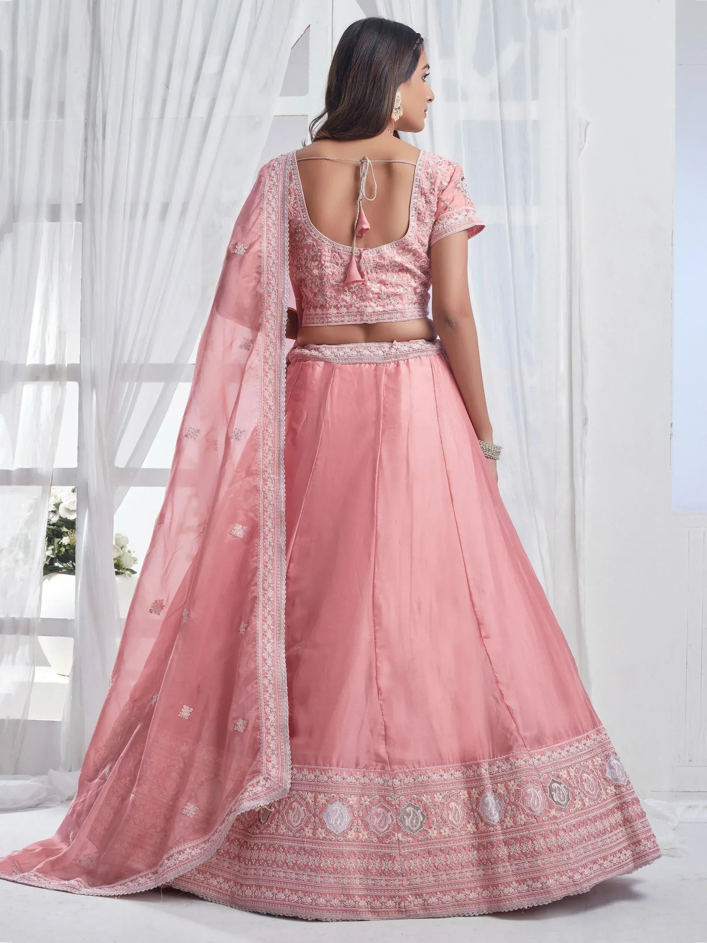 Pink embroidered lehenga choli with detailed border and sheer dupatta for ethnic wear
