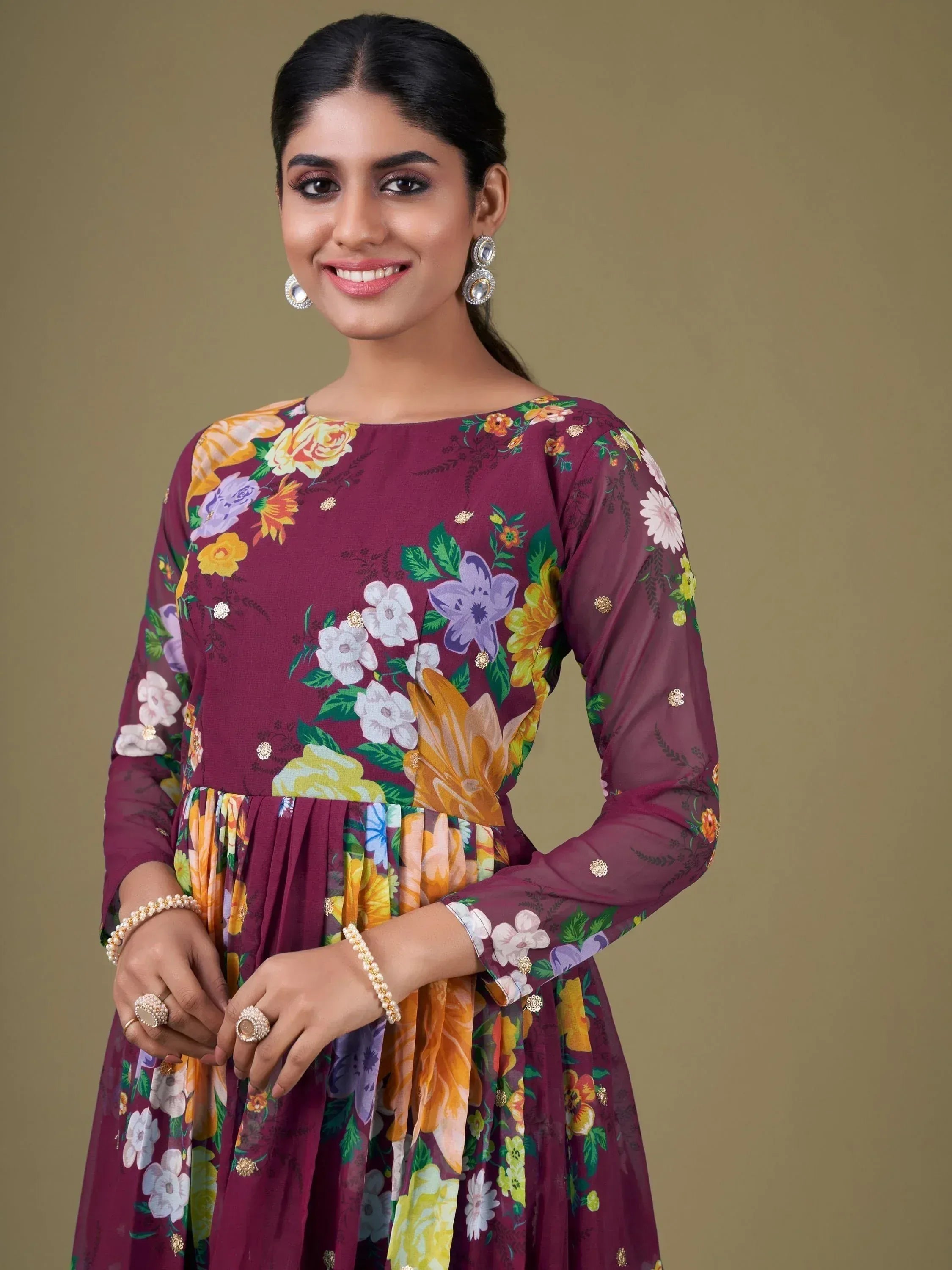 Woman in maroon floral ethnic gown with gold embellishments, perfect for Indian occasions