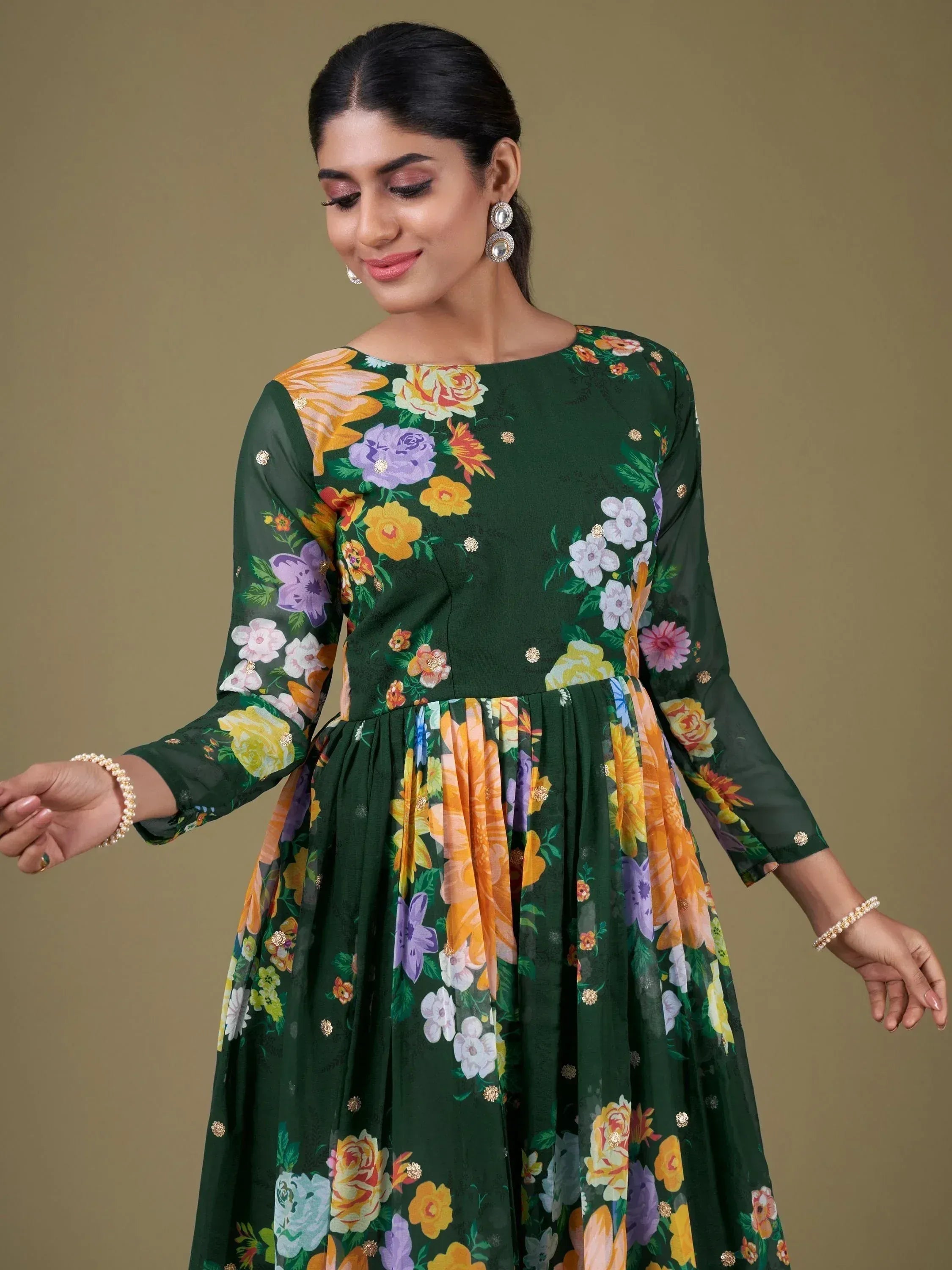 Green floral printed ethnic gown with vibrant blooms and gold accents, perfect for festive occasions.