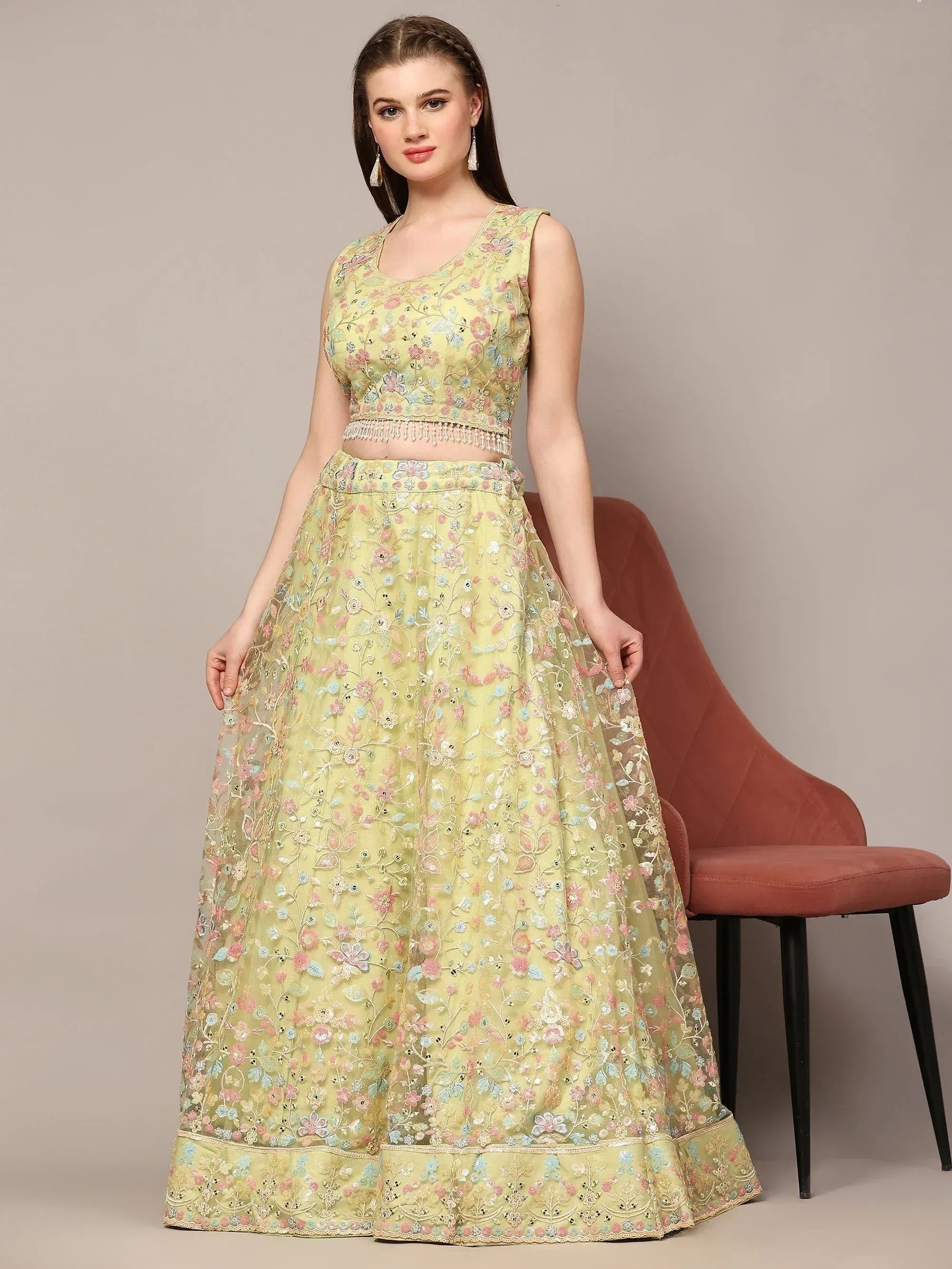 Light green floral embroidered lehenga choli with sleeveless crop top and flared skirt, perfect for Indian ethnic occasions.