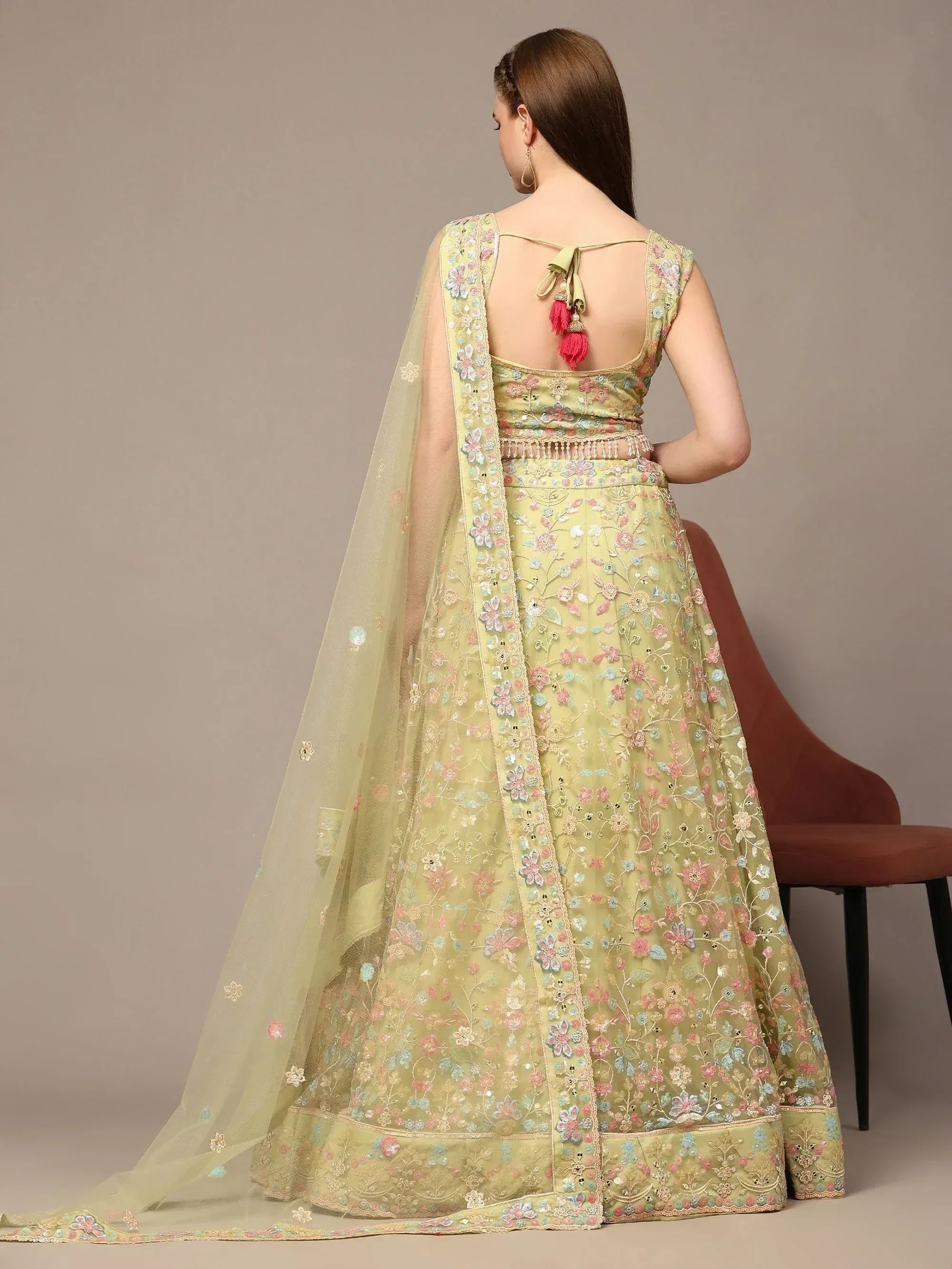 Light green floral embroidered lehenga choli with back tie and tassels, perfect for Indian ethnic occasions