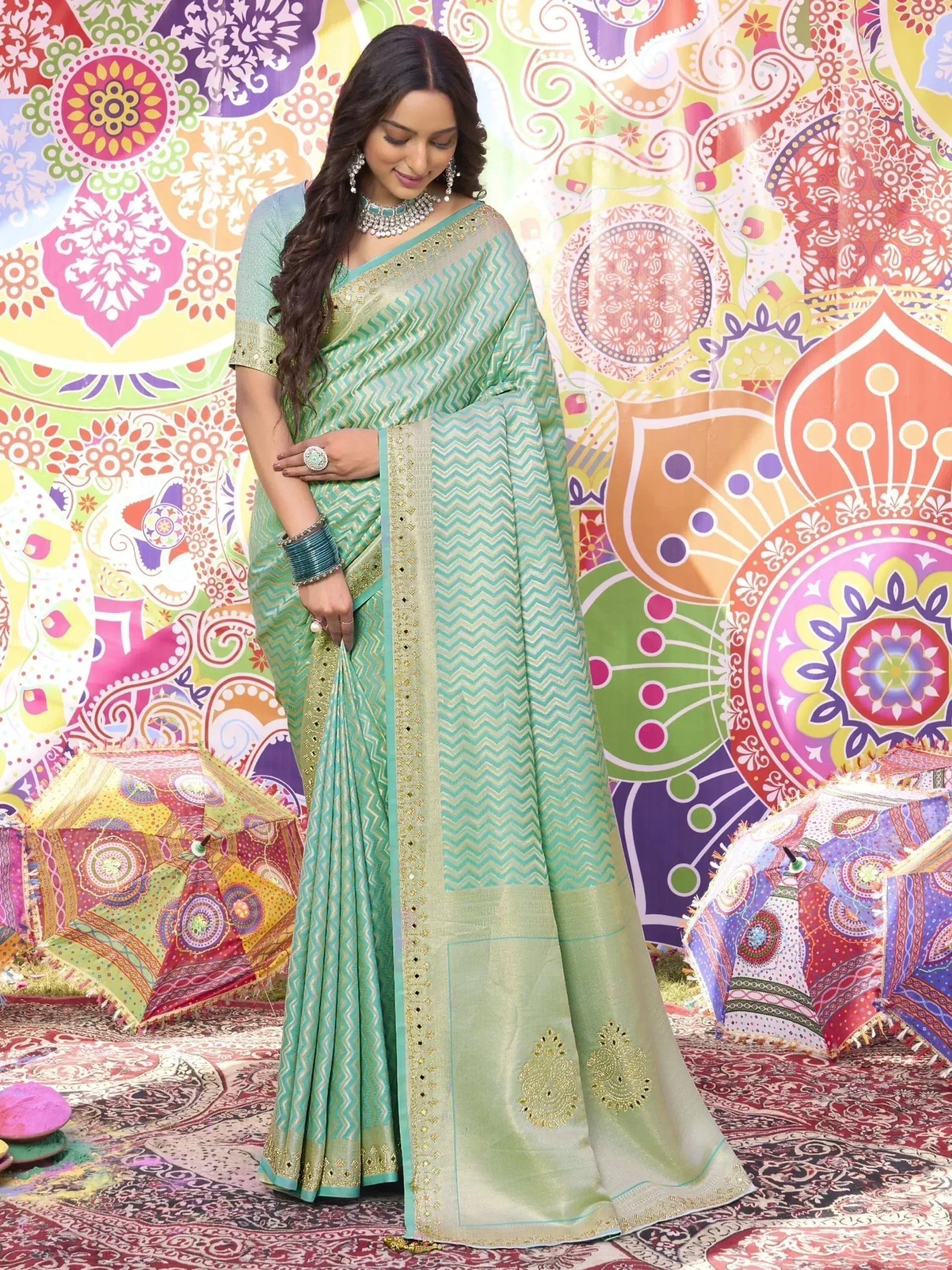 Woman in green and blue zigzag patterned saree with gold embroidery, festive Indian ethnic wear