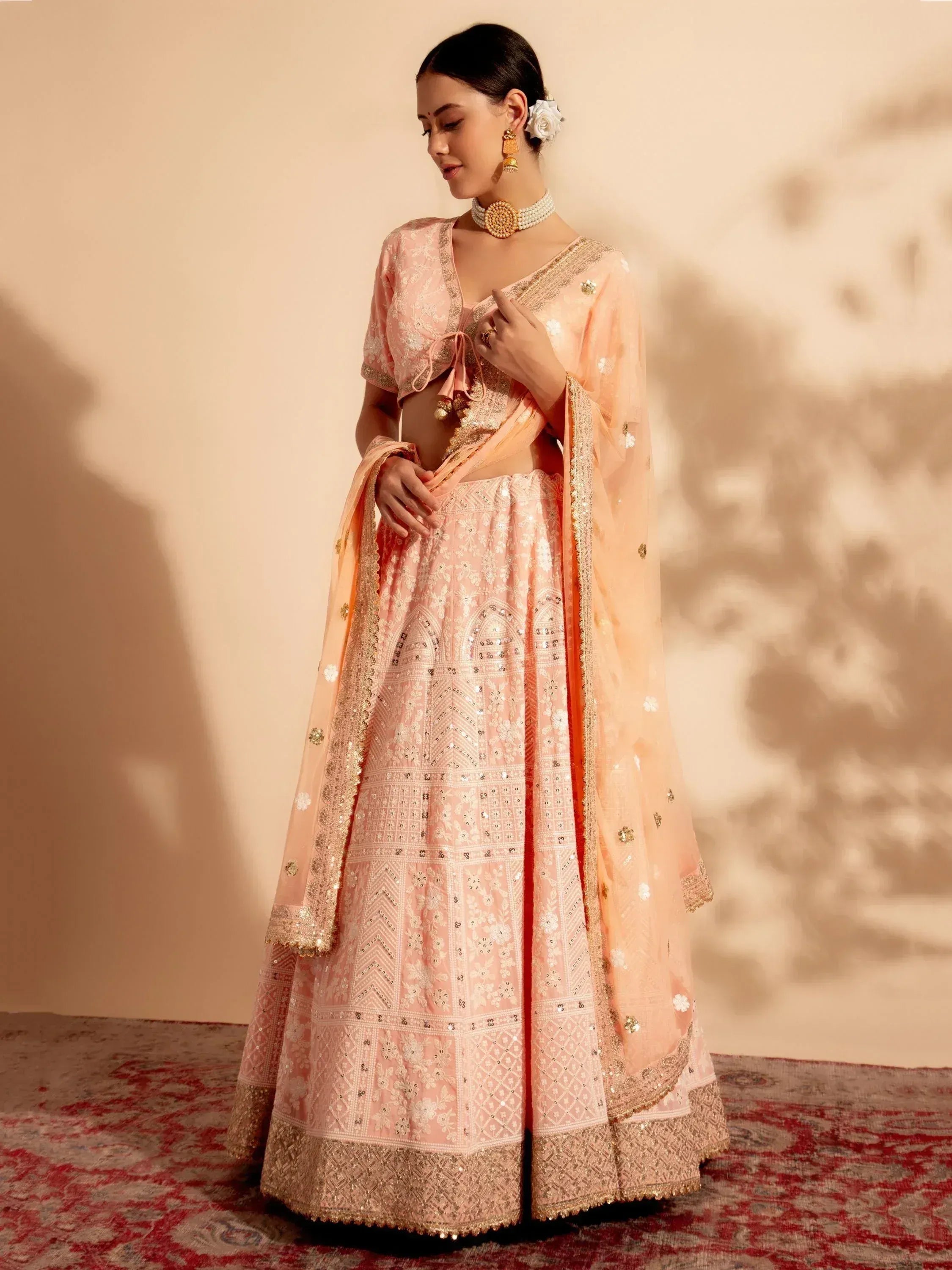 Pink embroidered lehenga choli with gold detailing, perfect for Indian weddings and festive occasions.