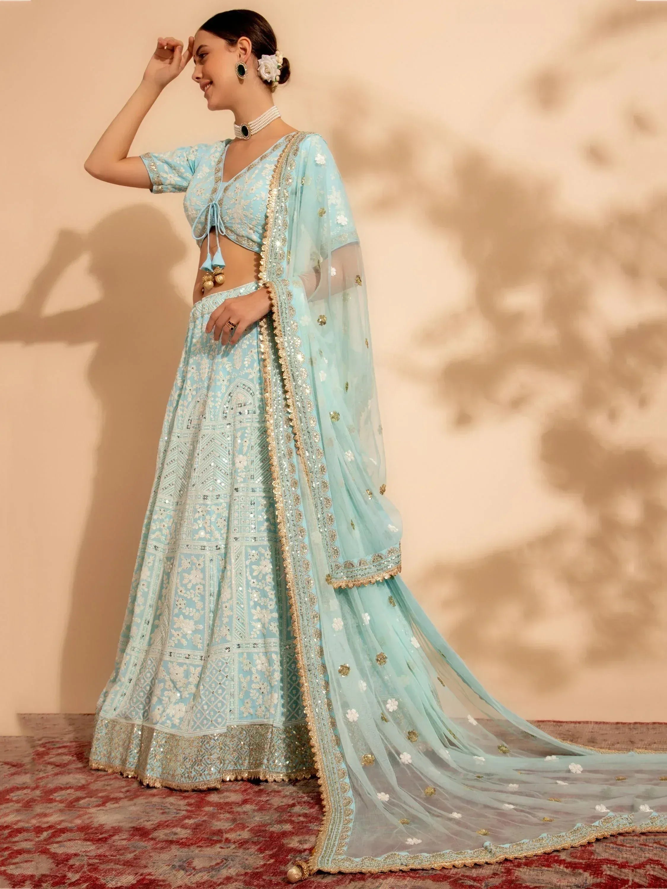 Light blue designer lehenga choli with gold embroidery and sheer dupatta, perfect for Indian weddings and festive occasions.