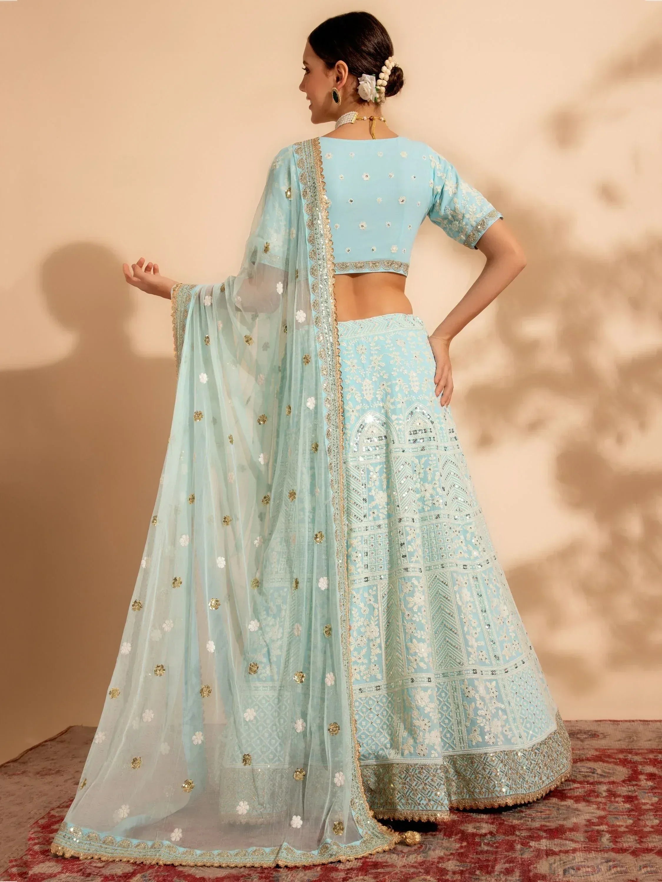 Light blue designer lehenga choli with gold embroidery and floral motifs, perfect for Indian ethnic wear.