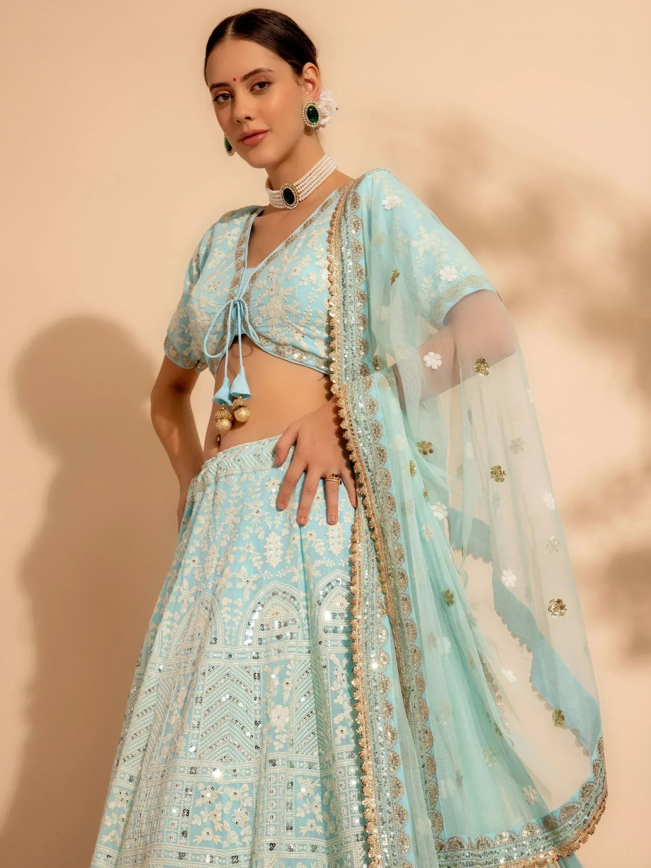 Light blue embroidered lehenga choli with gold detailing and sheer dupatta, perfect for Indian ethnic occasions.