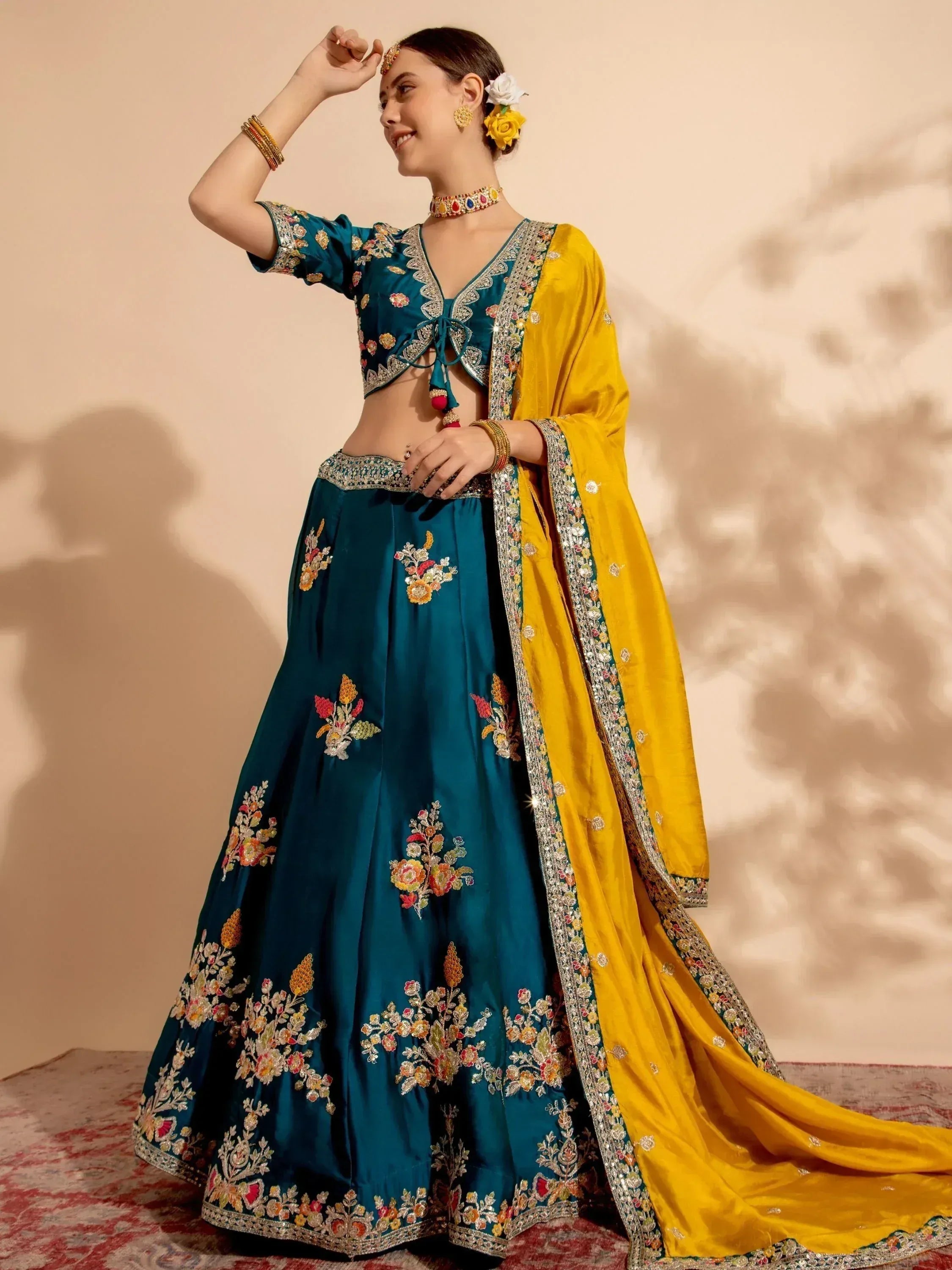 Teal embroidered lehenga choli with yellow dupatta, floral motifs, and traditional Indian ethnic wear