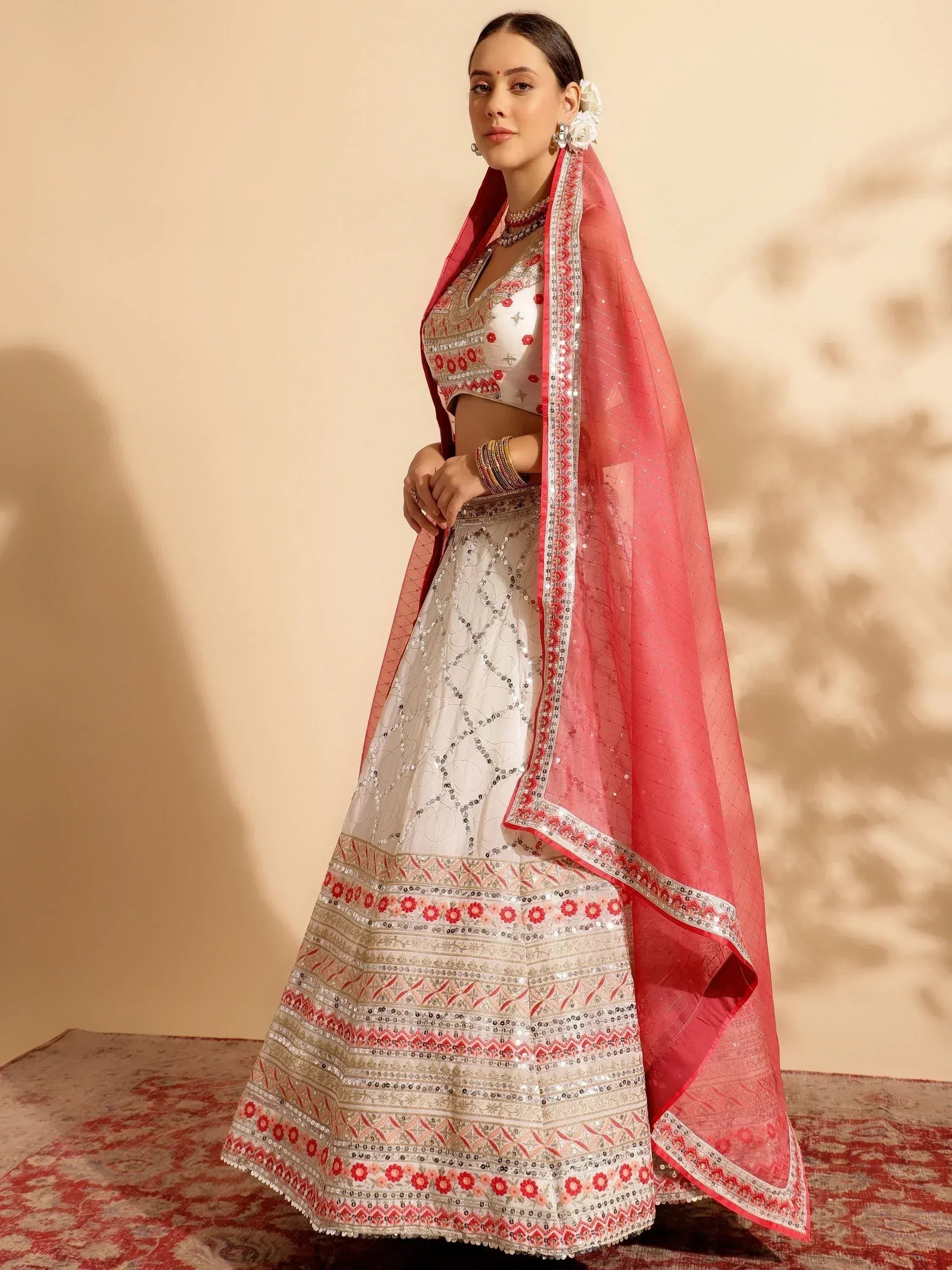 White and red embroidered lehenga choli with sequin work and matching dupatta, perfect for Indian weddings and festivals.