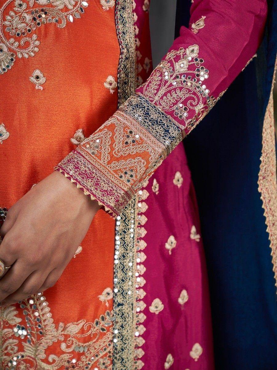 Orange and magenta ethnic salwar kameez with intricate gold embroidery and mirror work detailing