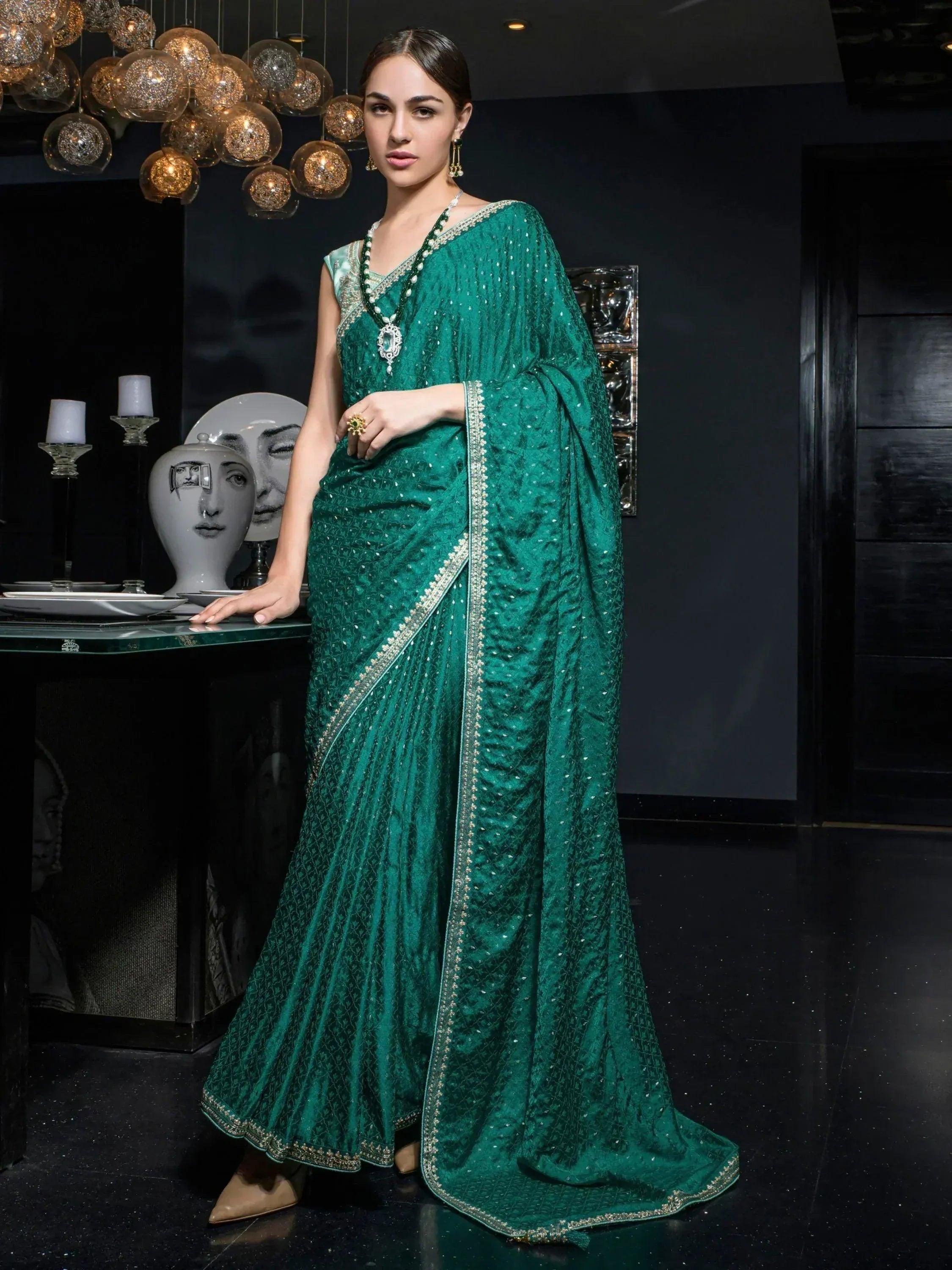 Emerald green designer saree with intricate embroidery and sequin detailing, perfect for ethnic occasions.