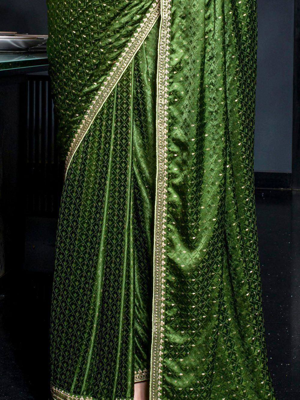 Emerald green velvet saree with gold embroidery and intricate leaf pattern, perfect for ethnic occasions.