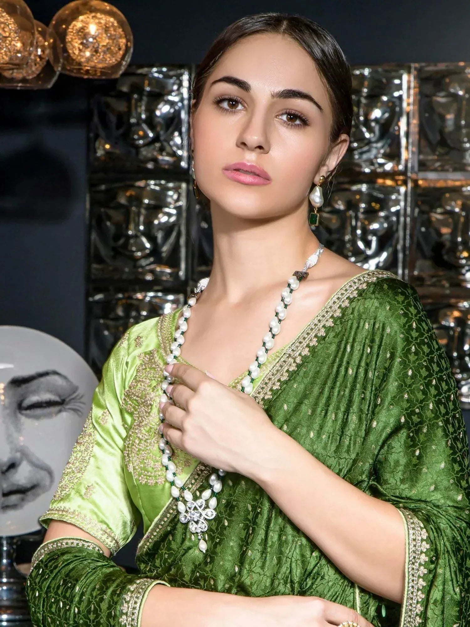 Woman in green ethnic gown with pearl necklace, elegant Indian wear for festive occasions