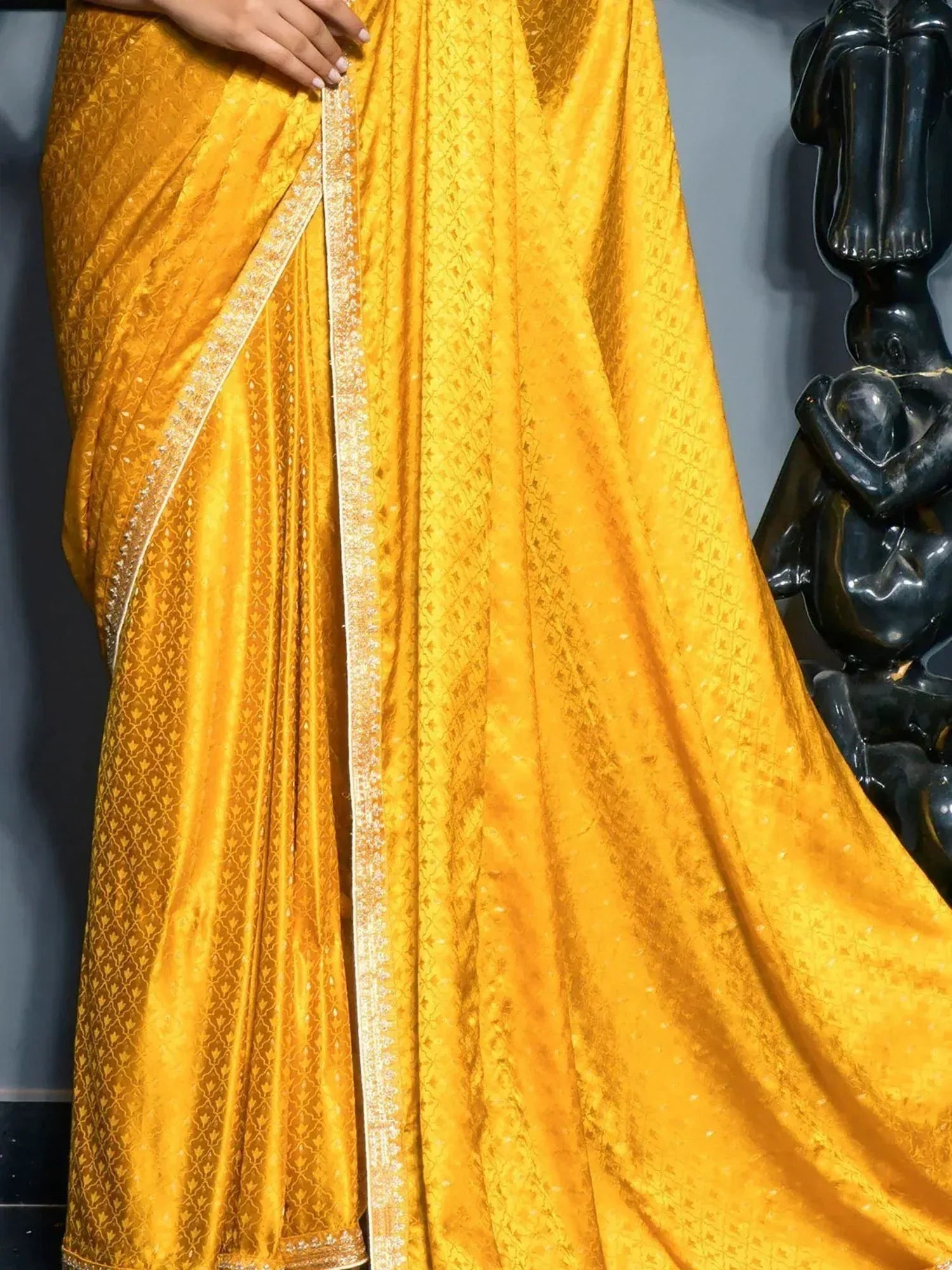 Golden yellow designer saree with intricate patterns and embellished border, perfect for ethnic occasions.