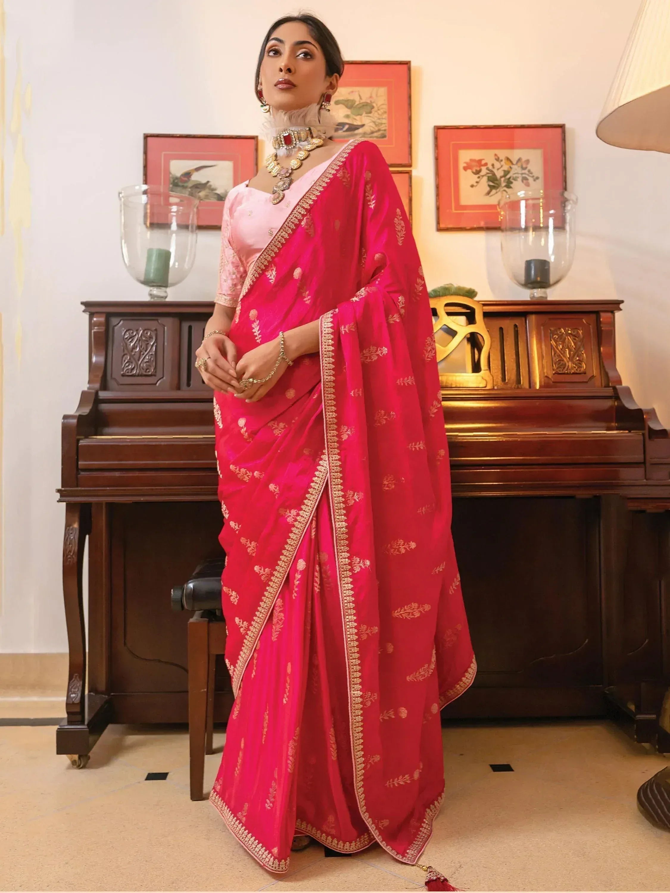 Pink and red embroidered saree with gold detailing, styled with traditional jewelry for Indian ethnic wear