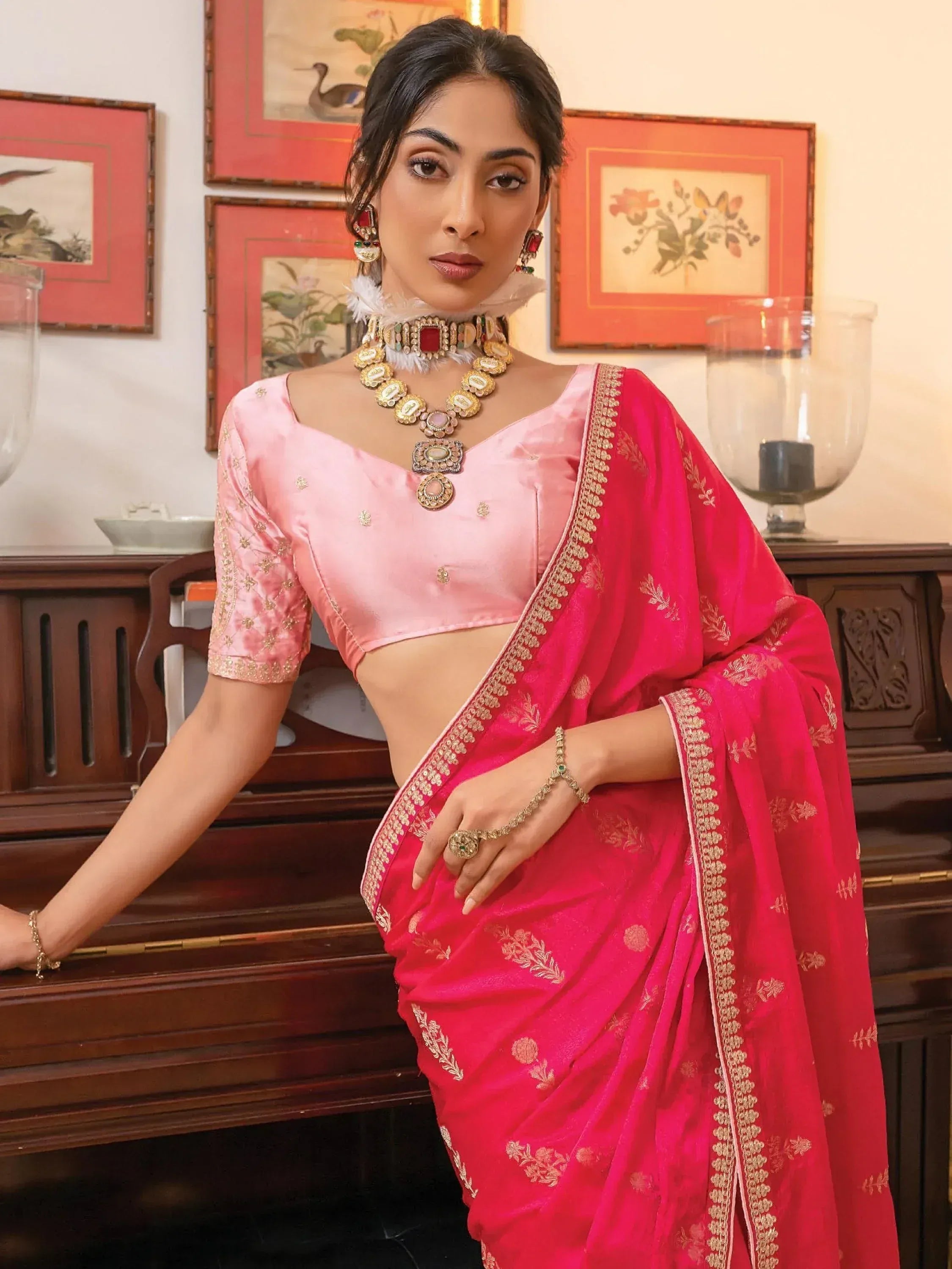Woman in pink embroidered saree with matching blouse, traditional Indian ethnic wear, gold jewelry