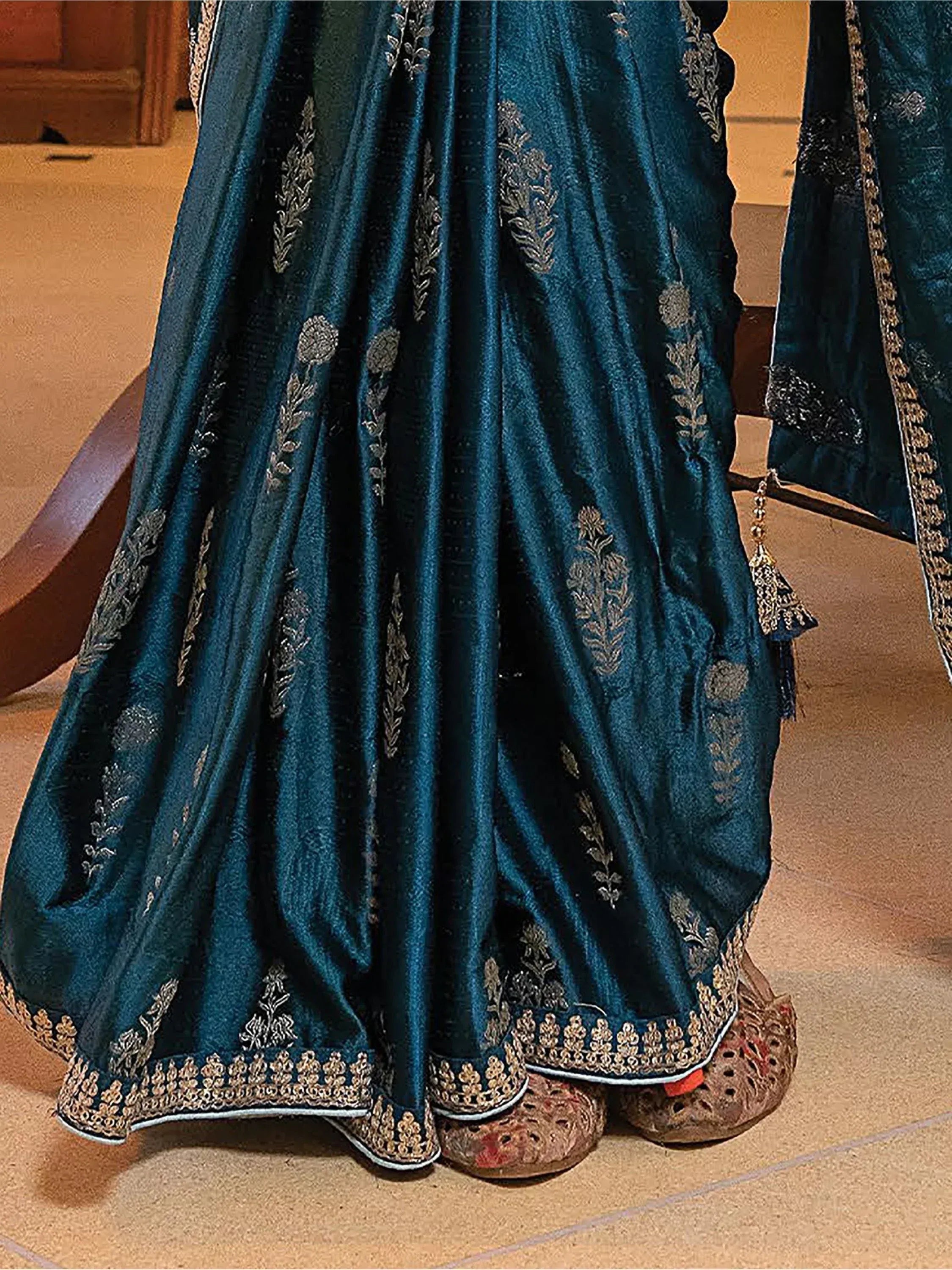 Teal velvet lehenga with gold floral embroidery and scalloped hem, paired with traditional juttis