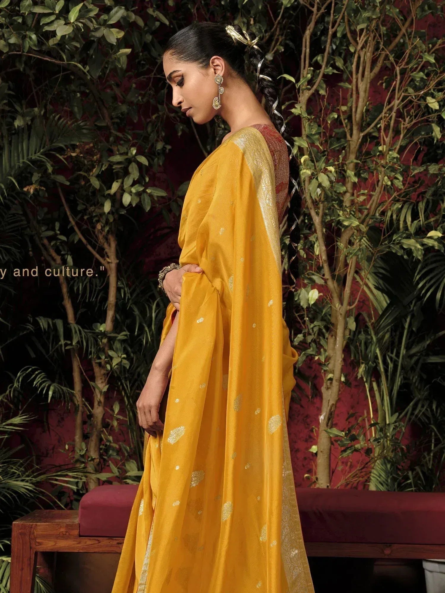 Yellow ethnic saree with gold motifs, styled with traditional jewelry and braided hair for festive occasions