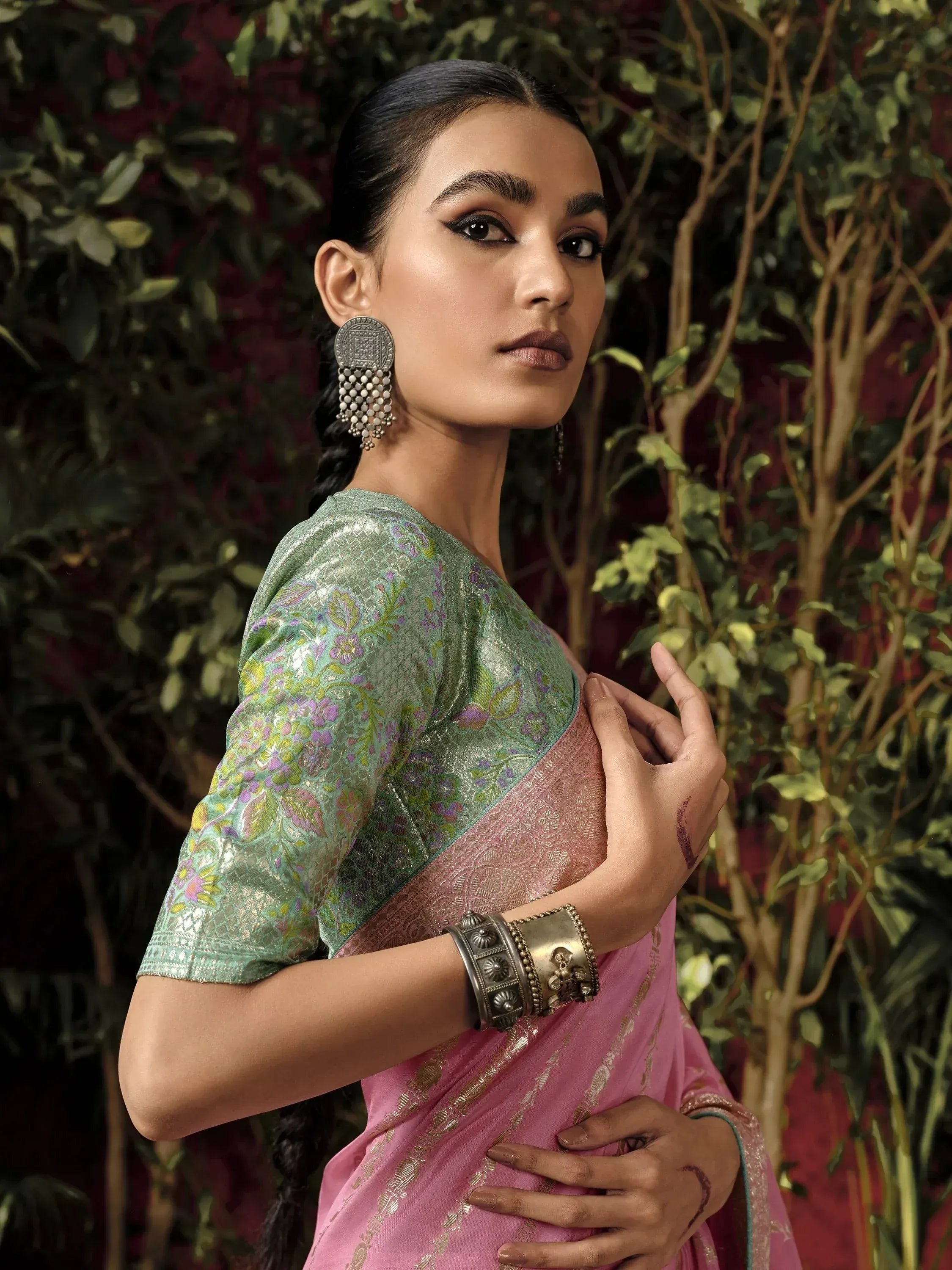 Woman in pink and green floral saree with ethnic jewelry, perfect for Indian ethnic wear occasions