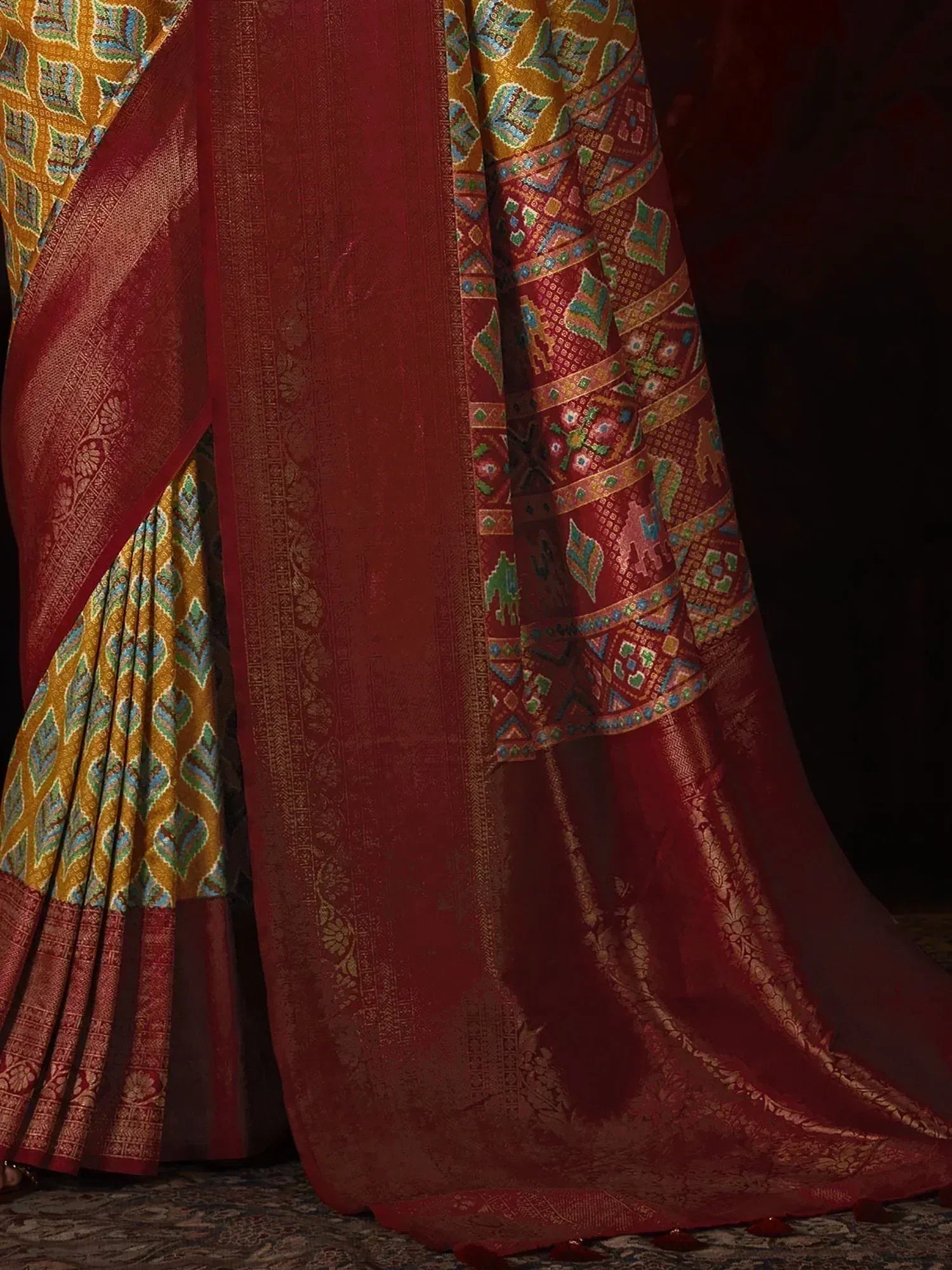Rich maroon and gold designer saree with intricate geometric and floral patterns, perfect for ethnic occasions.