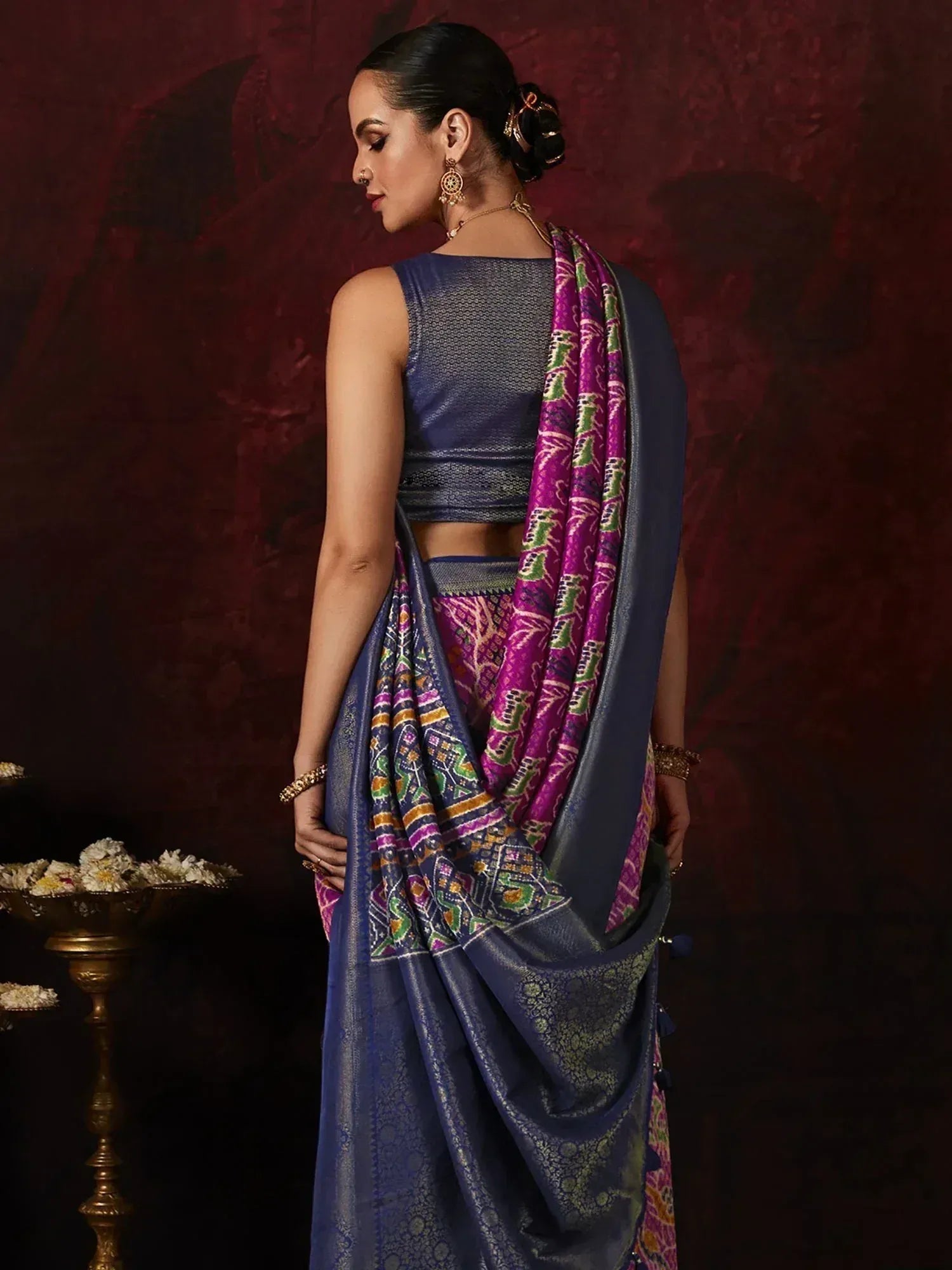 Woman in navy blue designer saree with purple and green ikat border, ethnic wear for festive occasions