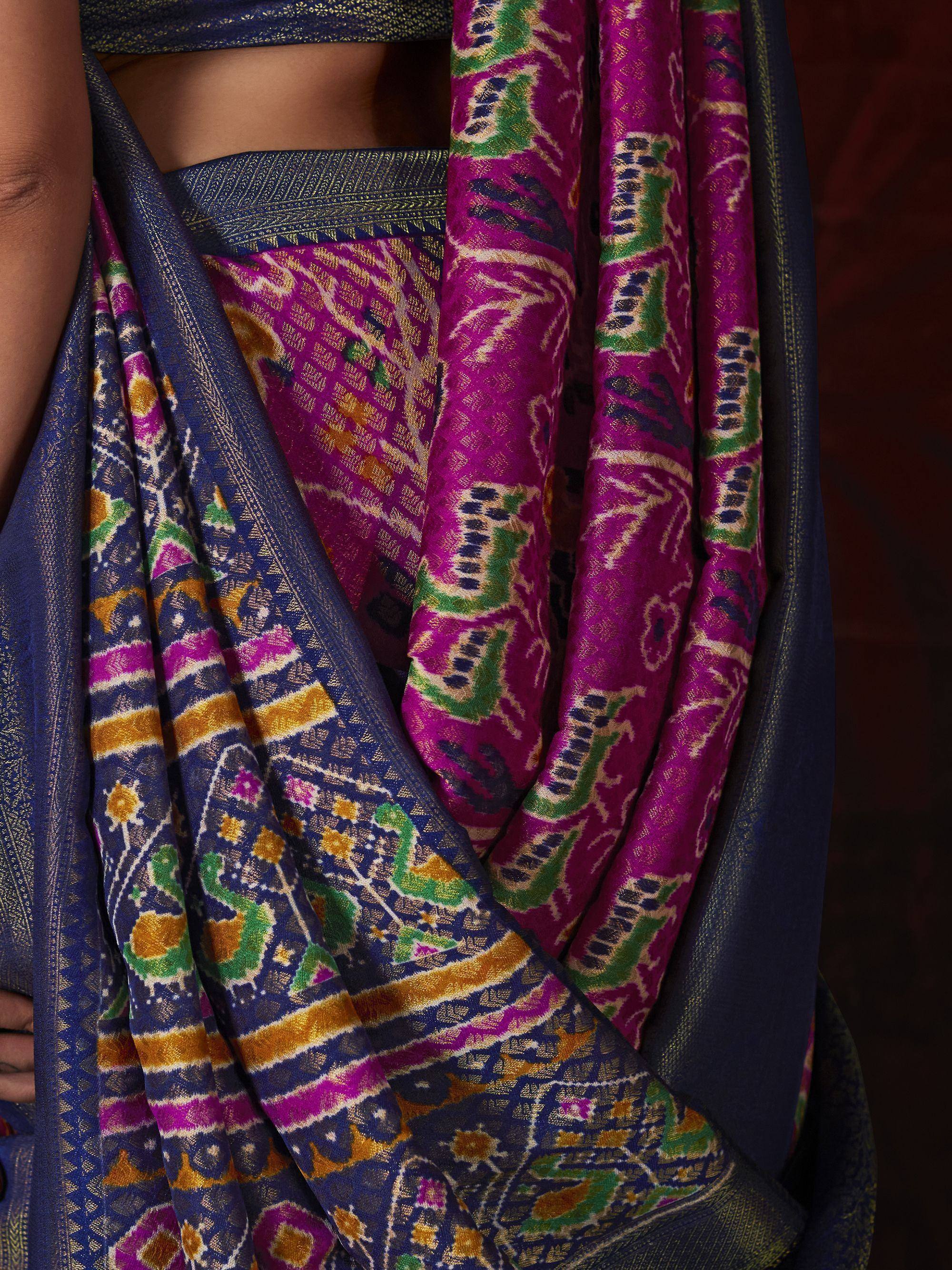 Vibrant purple and blue ikat saree with intricate geometric and floral patterns, perfect for Indian ethnic wear.