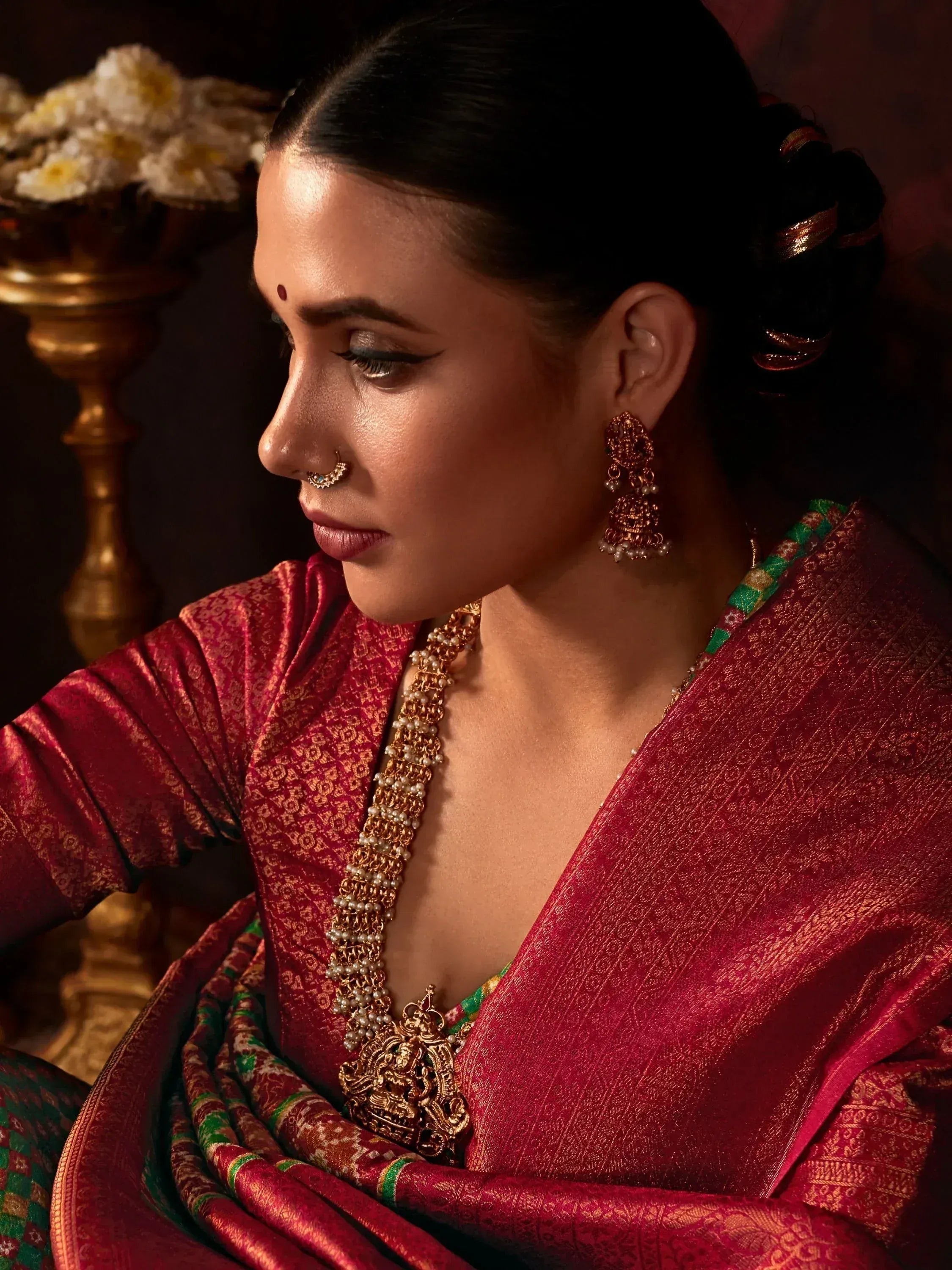 Woman in red ethnic saree with gold jewelry, traditional Indian bridal look