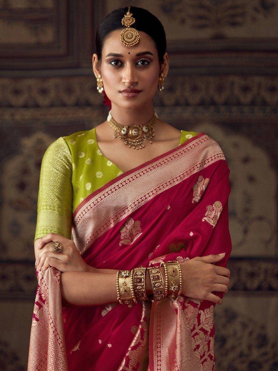 Woman in maroon silk saree with gold embroidery, paired with green blouse and traditional Indian jewelry