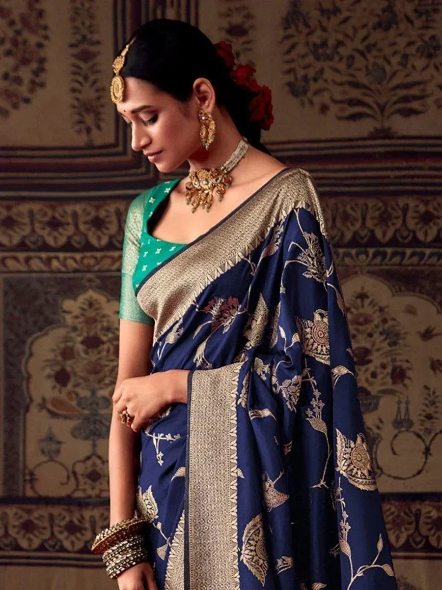 Navy blue floral saree with gold border, paired with green blouse and traditional jewelry for ethnic wear.