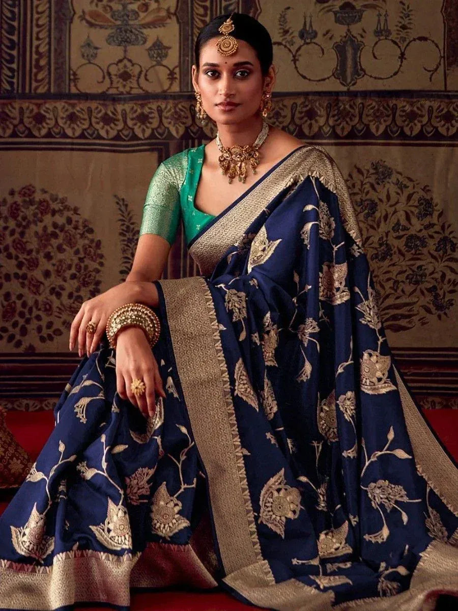 Navy blue floral saree with gold embroidery, paired with green blouse and traditional jewelry for ethnic wear