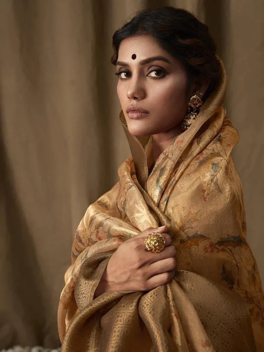 Elegant woman in golden floral saree with traditional jewelry, perfect for Indian ethnic occasions.