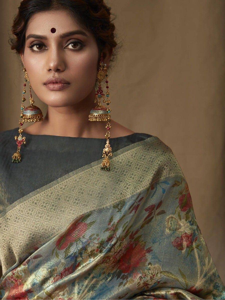Woman in floral printed saree with gold border and traditional jhumka earrings, ethnic Indian wear