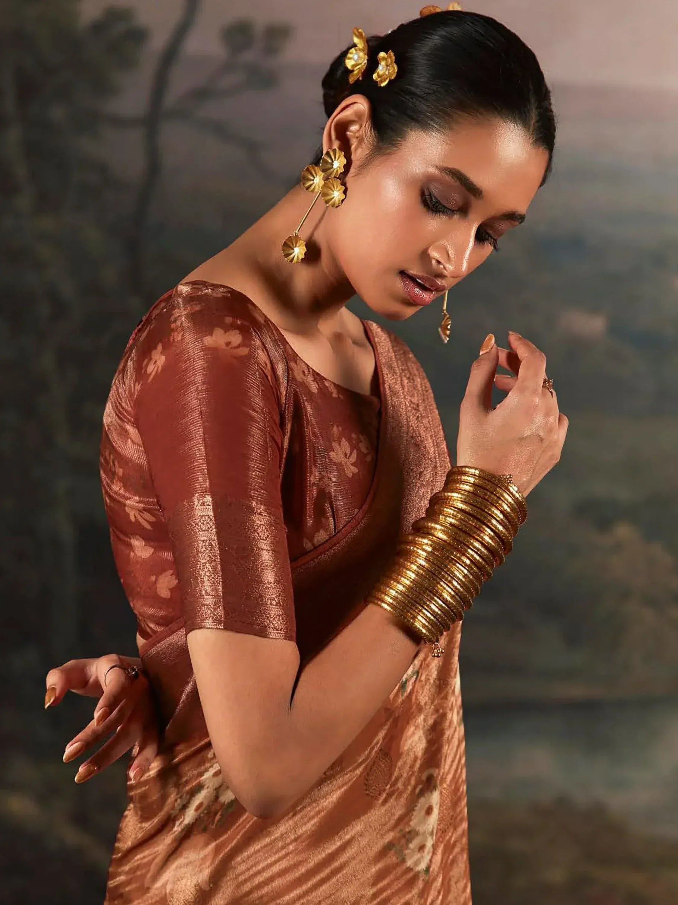 Elegant woman in copper floral saree with gold jewelry, perfect for Indian ethnic occasions