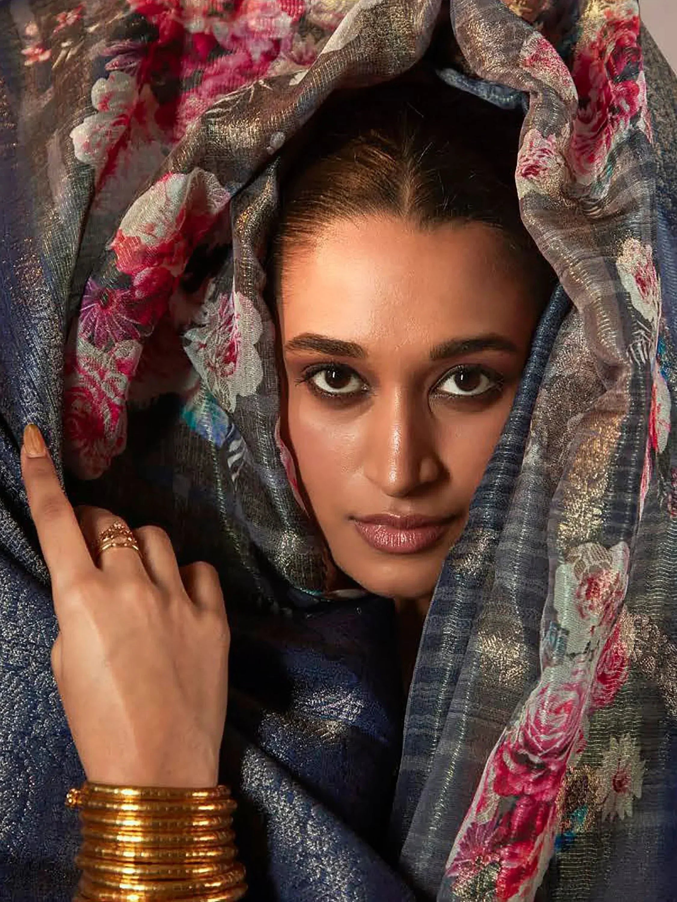 Woman in floral dupatta and ethnic attire with gold bangles, showcasing Indian fashion