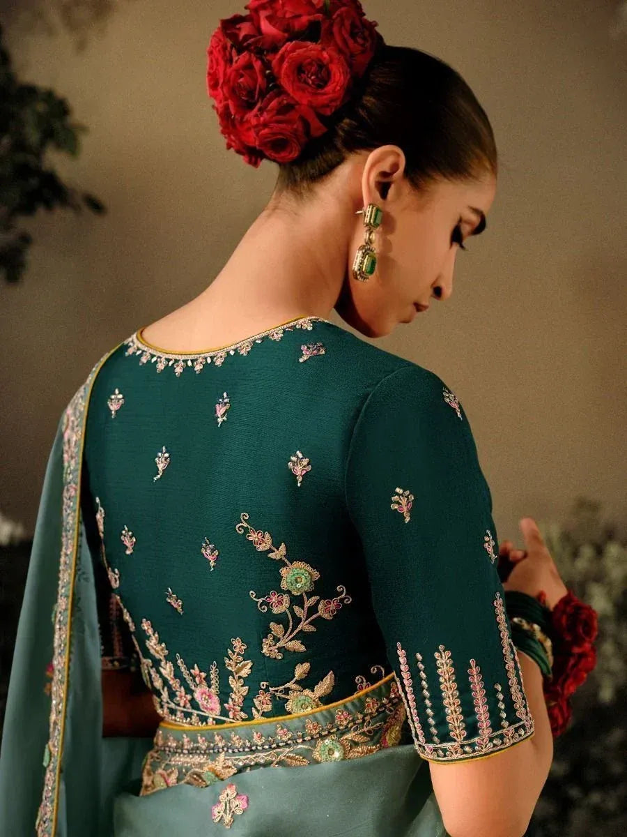 Elegant teal embroidered lehenga choli with floral detailing and red rose hair accessory