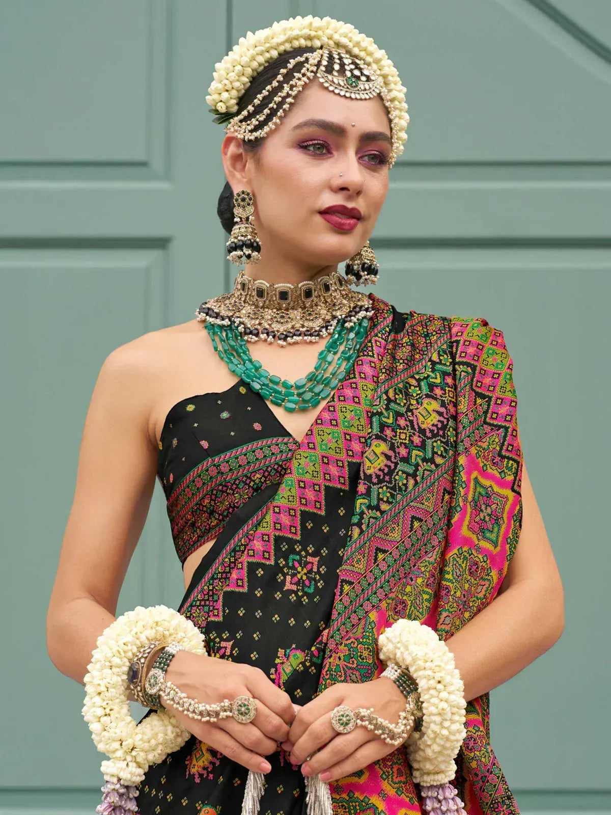 Woman in vibrant ethnic saree with floral jewelry, traditional Indian attire for weddings or festivals