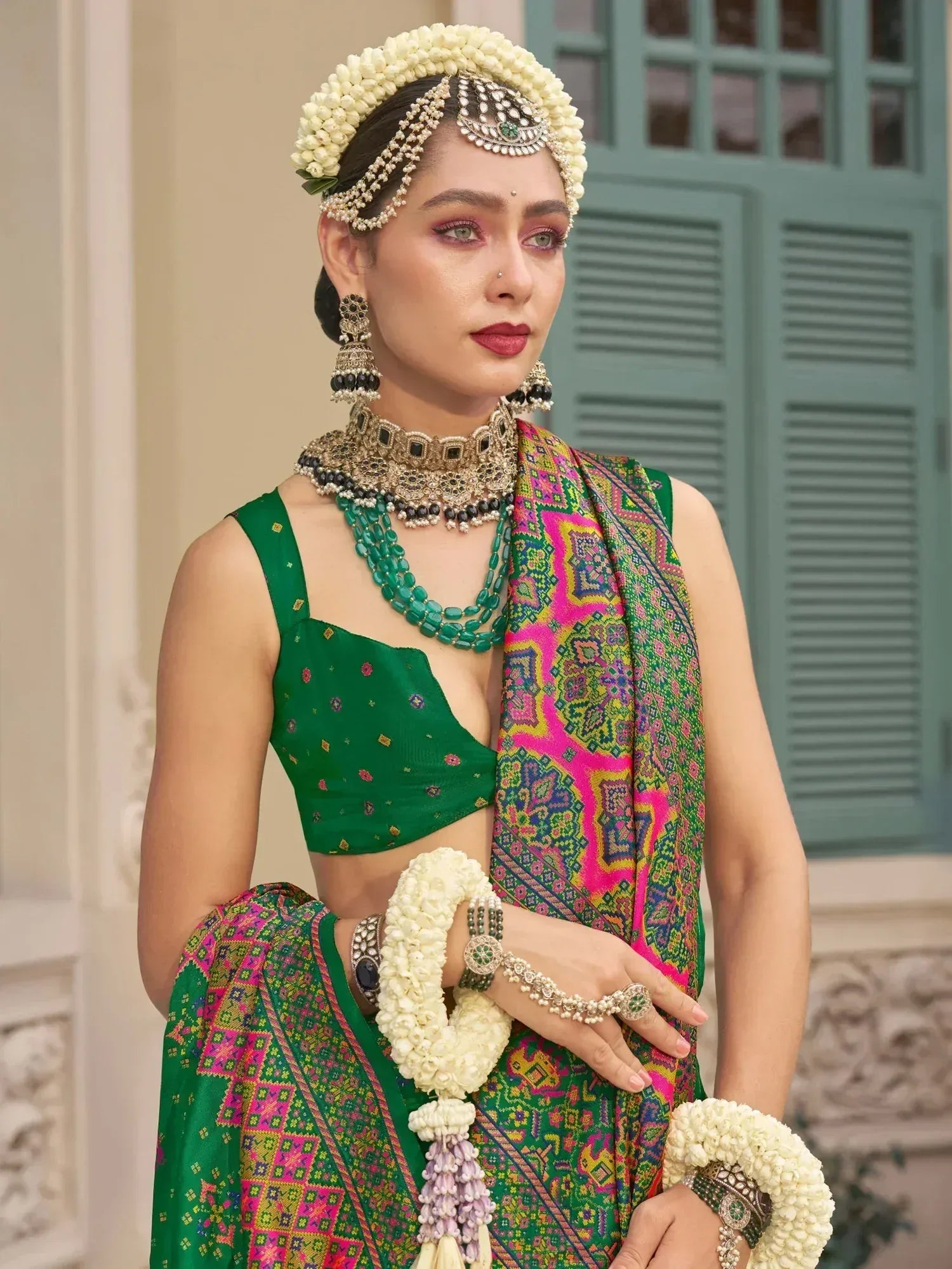 Green ethnic lehenga choli with floral jewelry and colorful dupatta, perfect for Indian weddings and festive occasions.