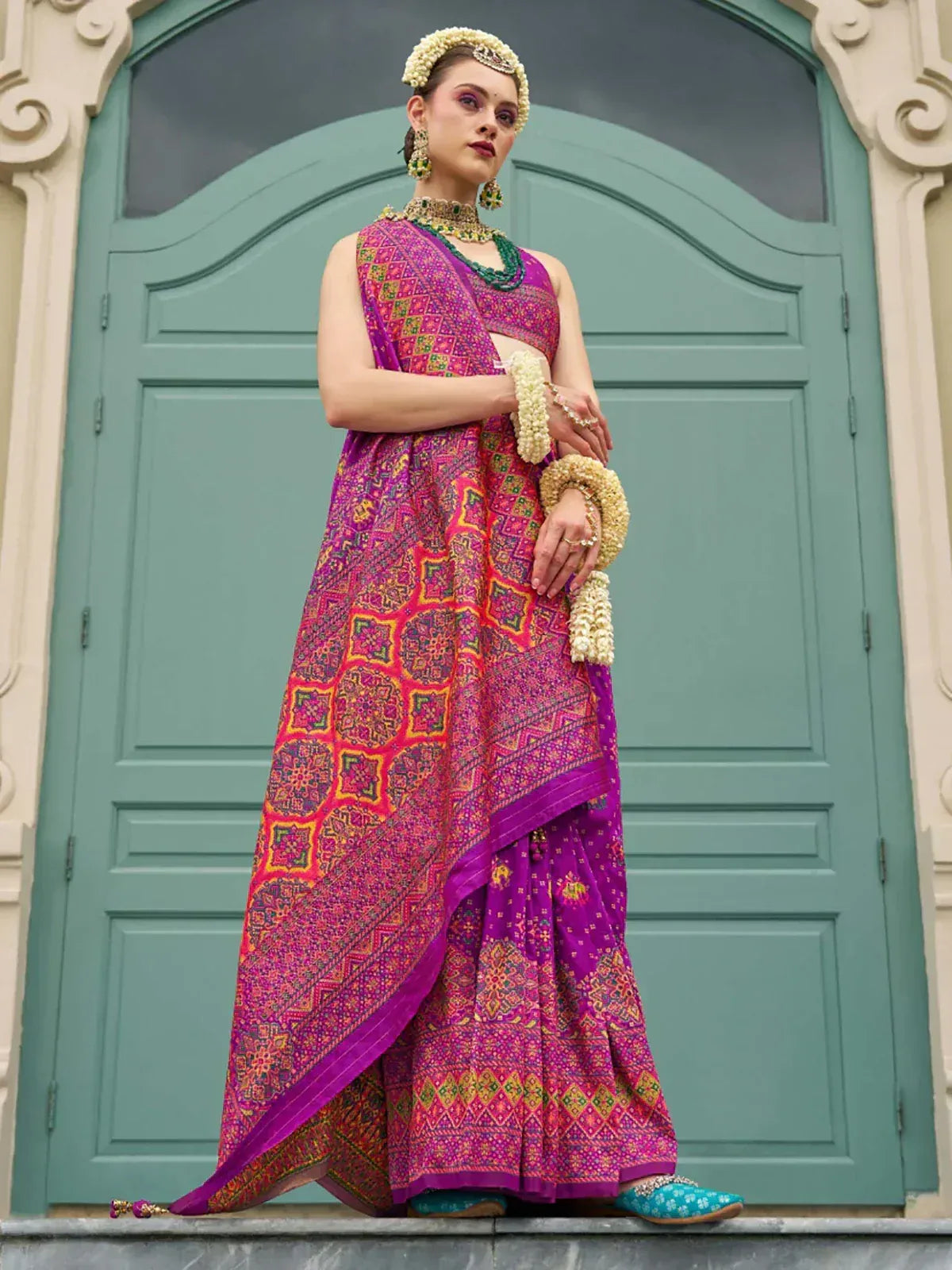 Vibrant purple and pink printed lehenga choli with floral jewelry, perfect for Indian ethnic occasions
