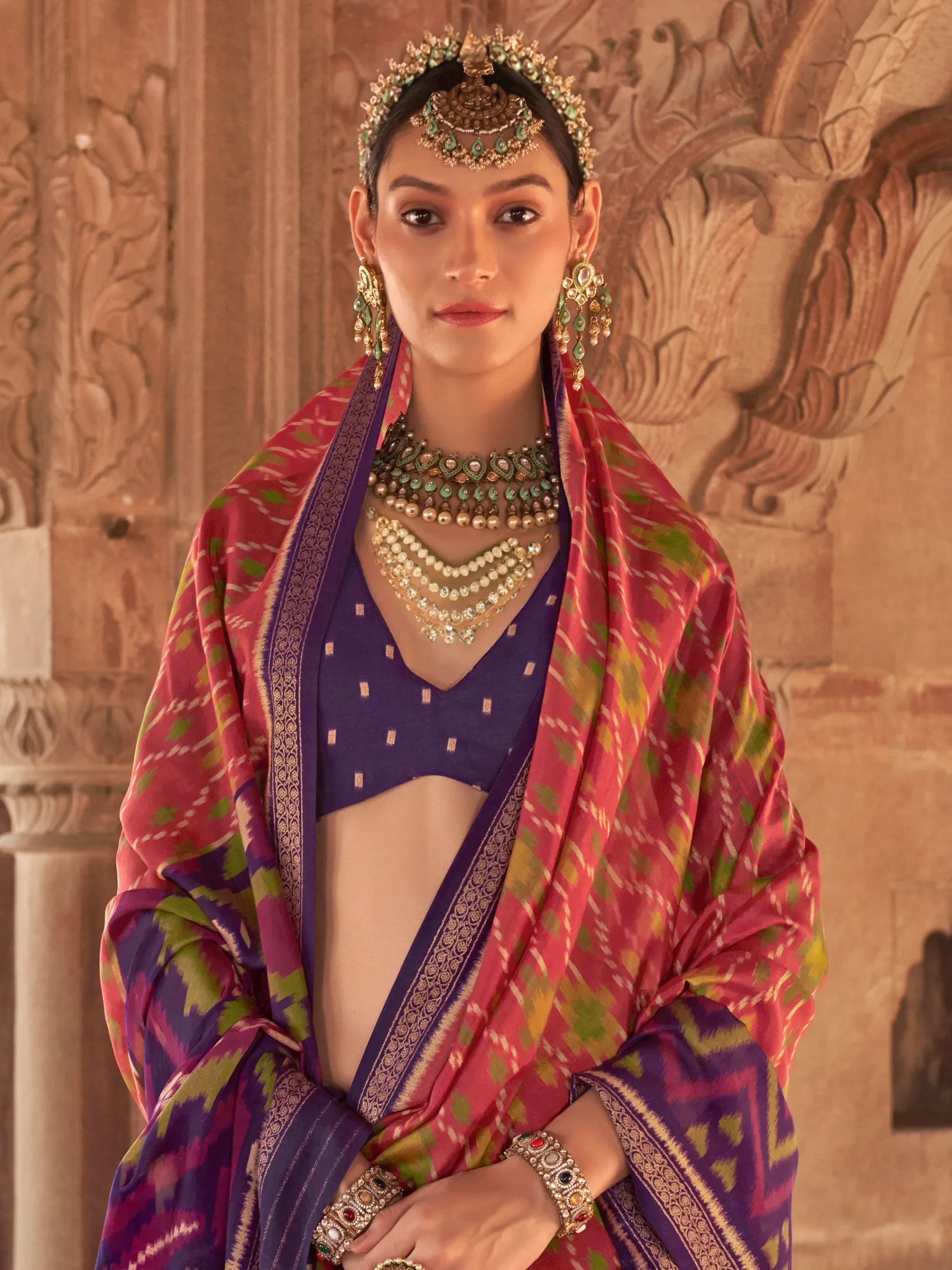 Bewitching Coral Red Patola Printed Georgette Saree With Purple Blouse