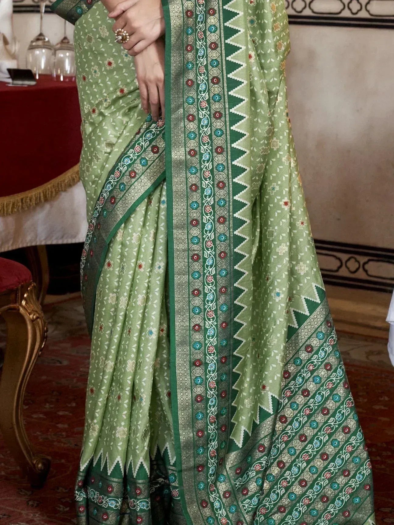 Green ethnic saree with floral and geometric border, perfect for Indian occasions