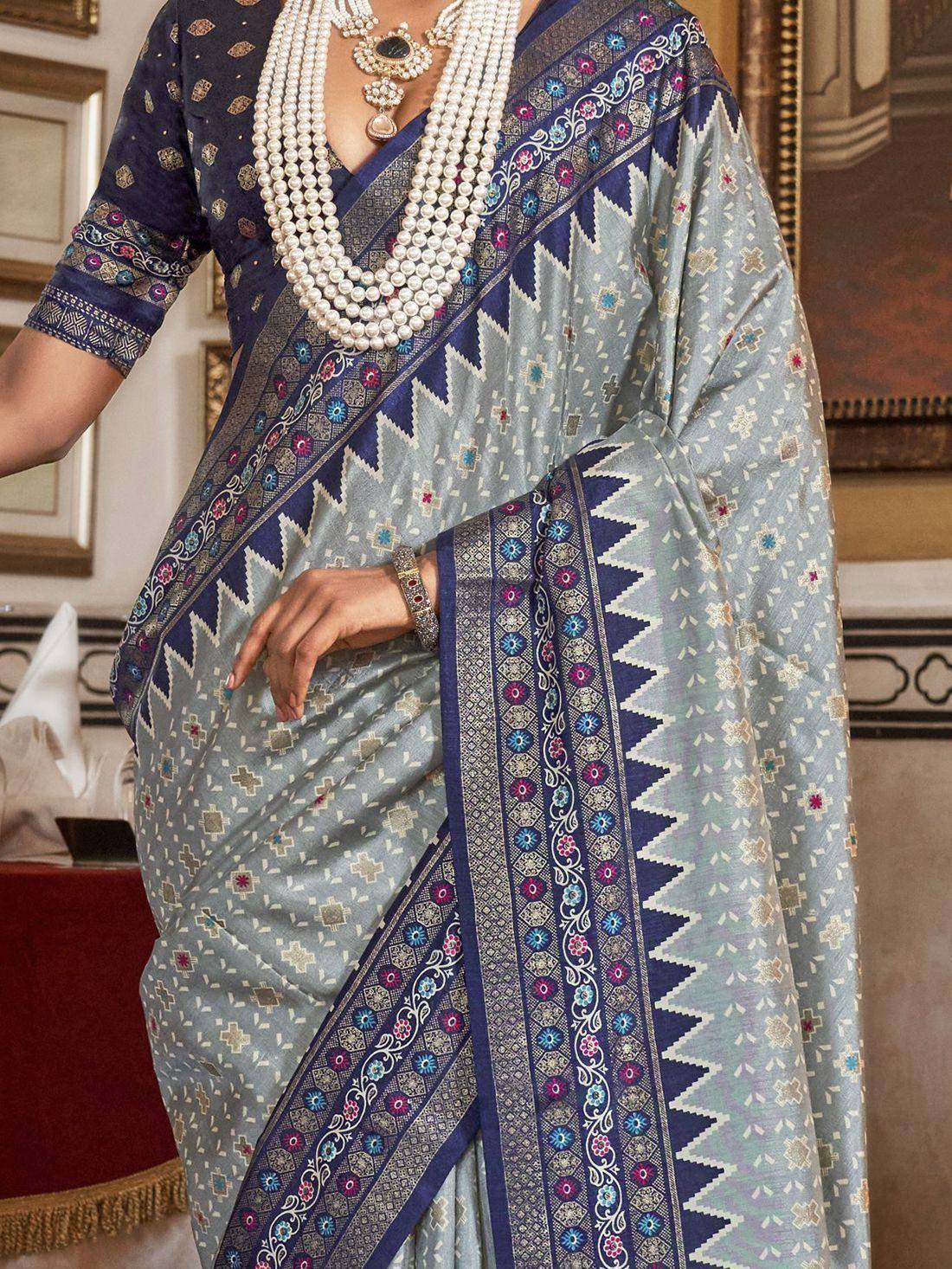 Elegant light blue saree with navy border, floral motifs, and pearl jewelry for Indian ethnic wear