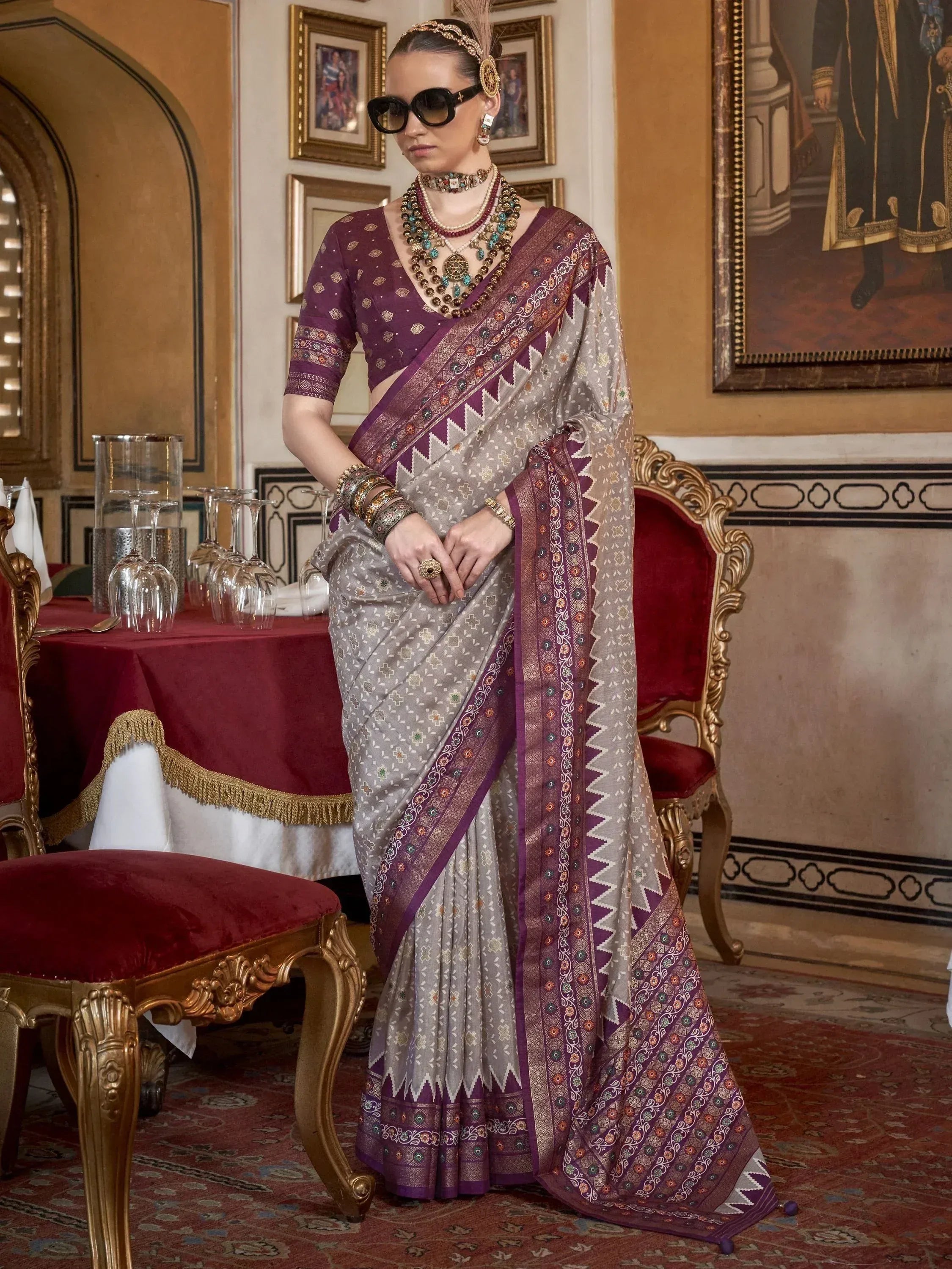 Elegant woman in designer ethnic saree with purple blouse, intricate embroidery, and traditional jewelry
