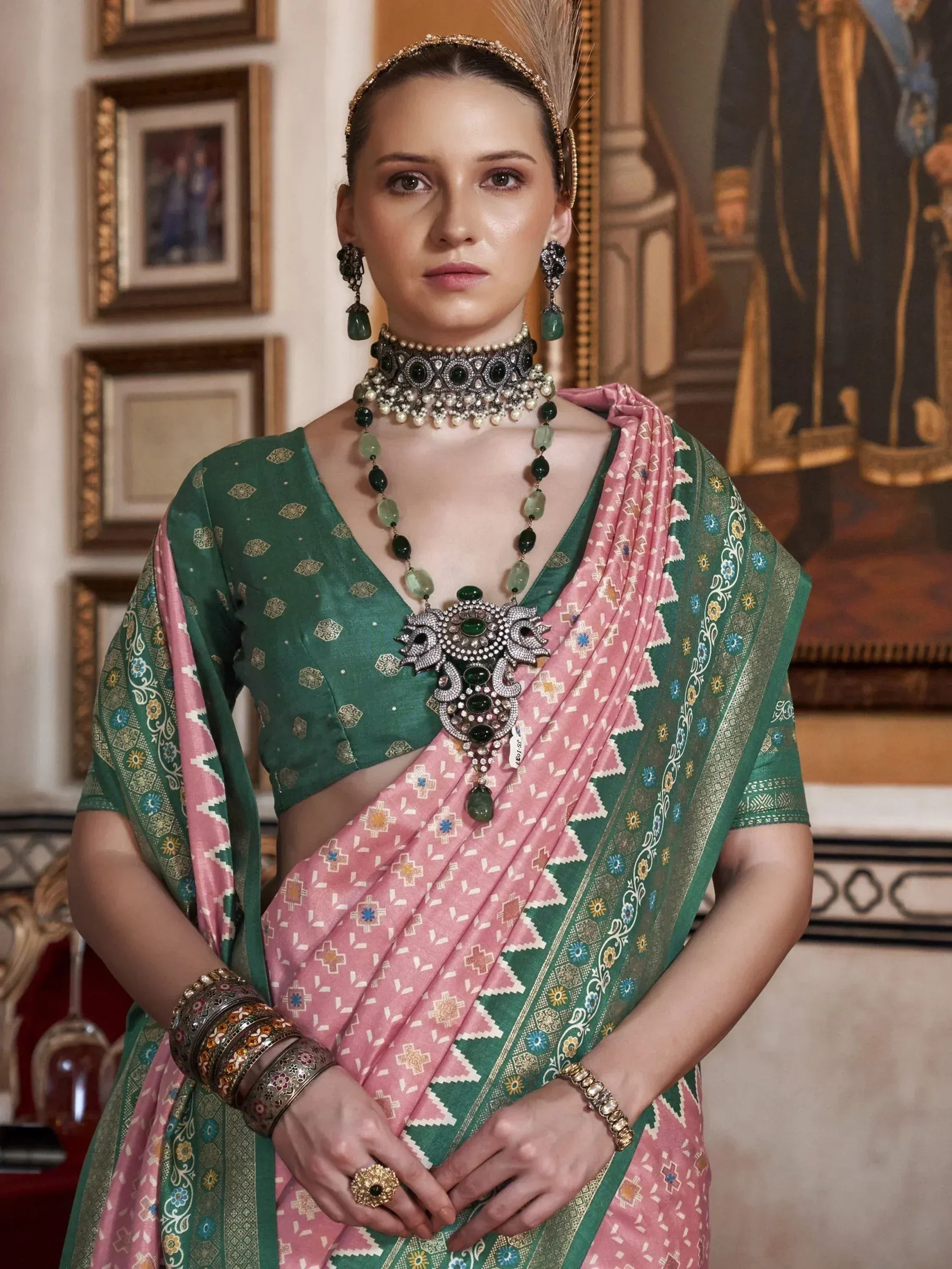 Elegant woman in green and pink printed saree with heavy jewelry, traditional Indian ethnic wear