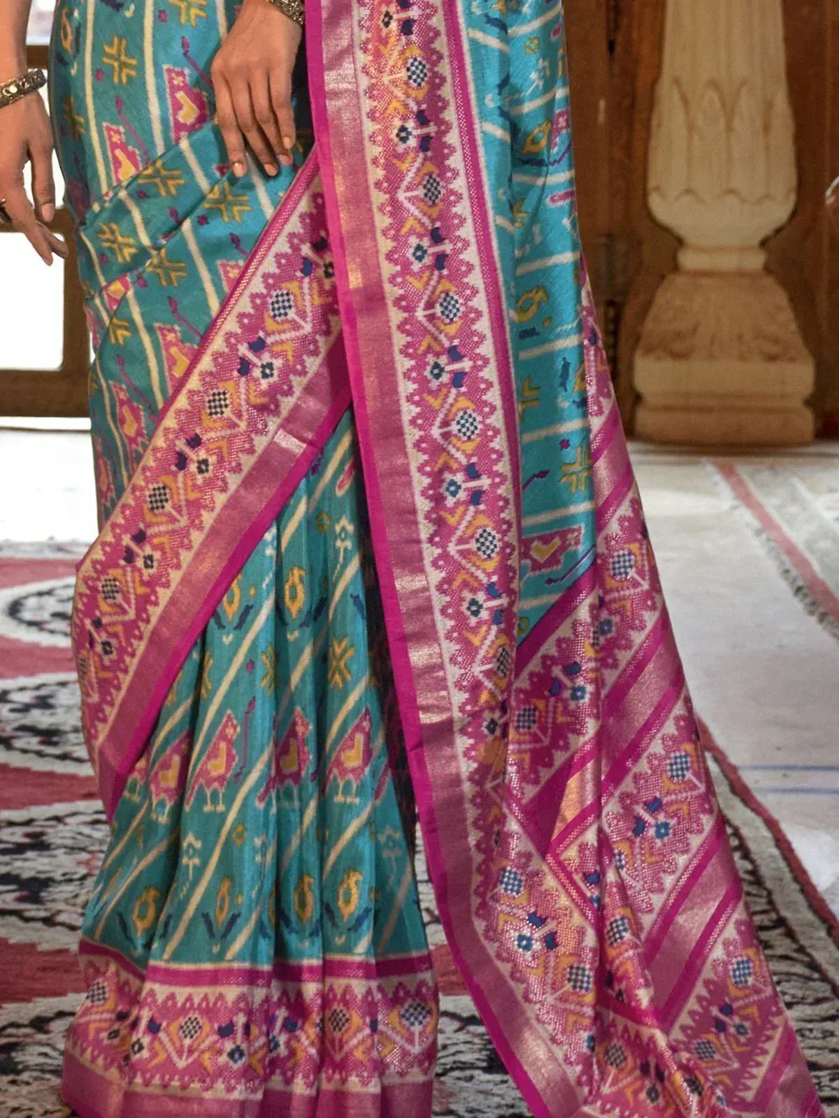 Turquoise and pink ethnic saree with intricate geometric patterns and woven border, perfect for Indian occasions