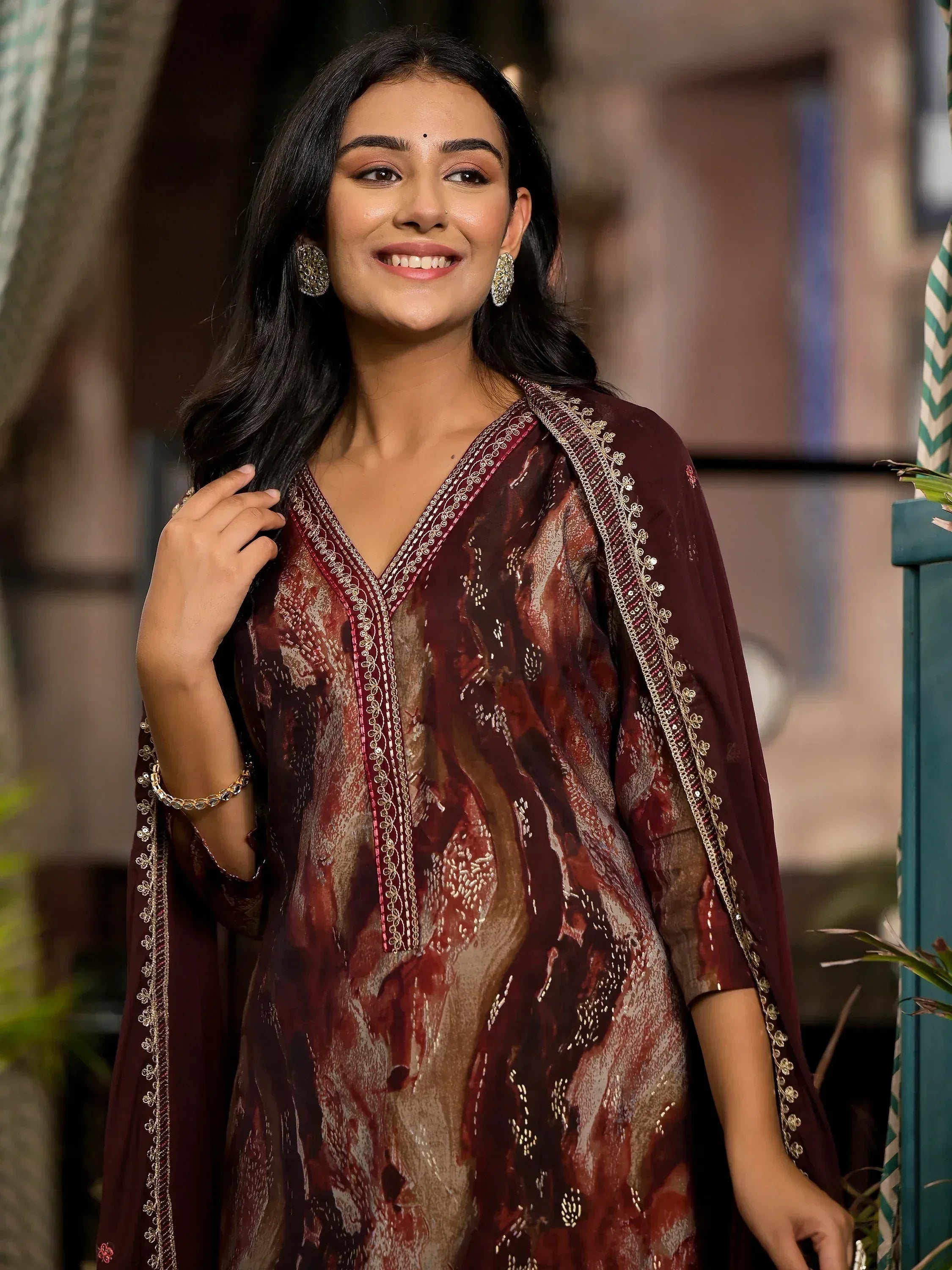 Woman in maroon printed ethnic kurta with gold embroidery, styled for Indian occasions